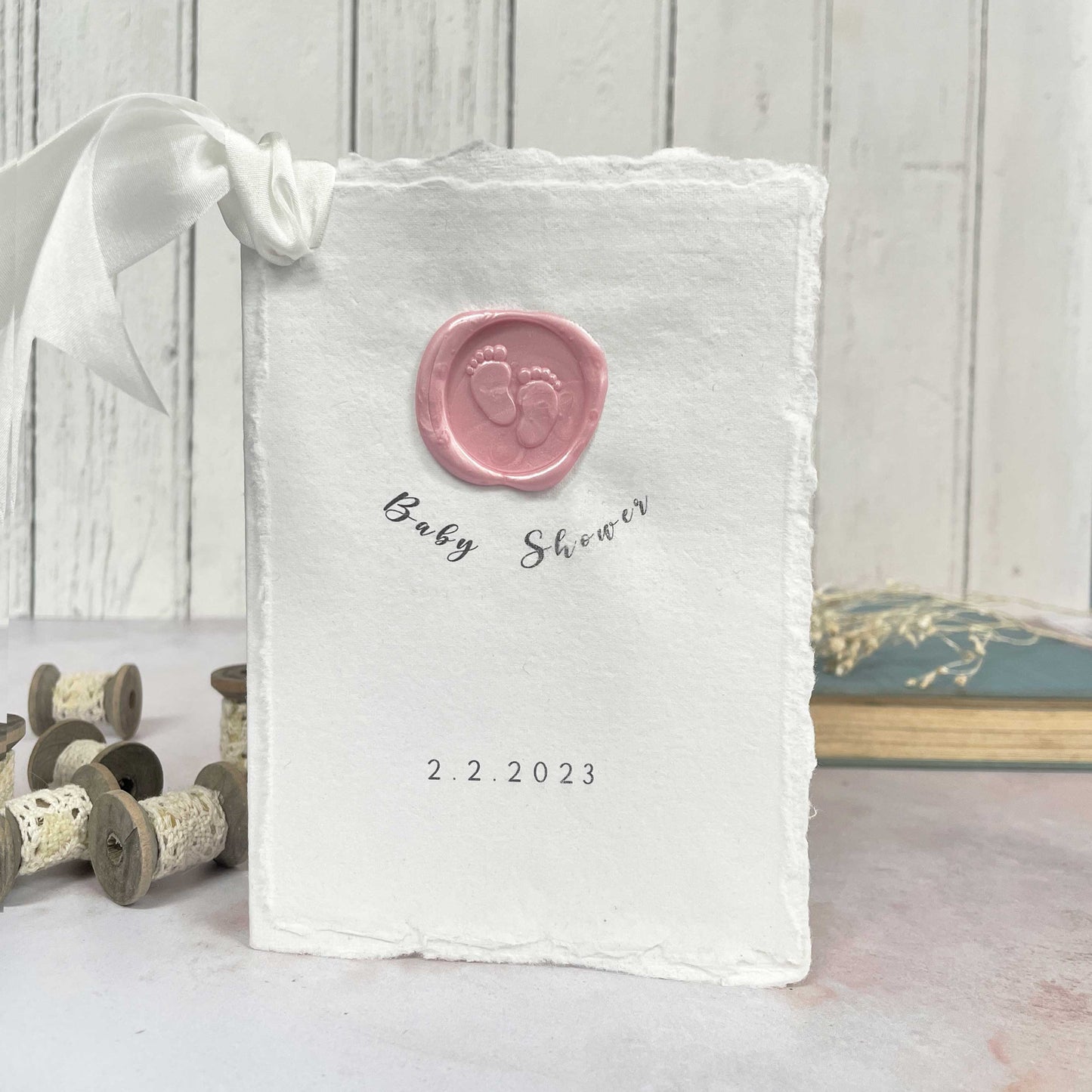 Handmade baby shower invitation with handmade paper and a wax seal with baby feet design.  By The Natural Paper Company
