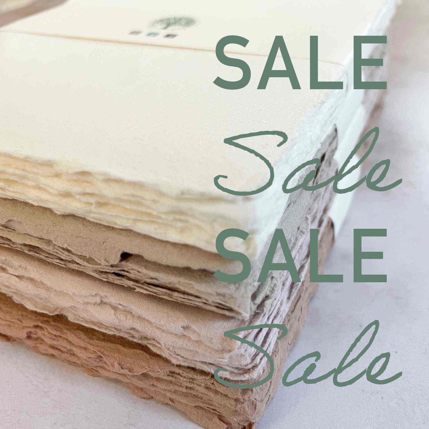 Stack of textured handmade natural paper in off‑white, cream and earthy brown tones — The Natural Paper Company sale
