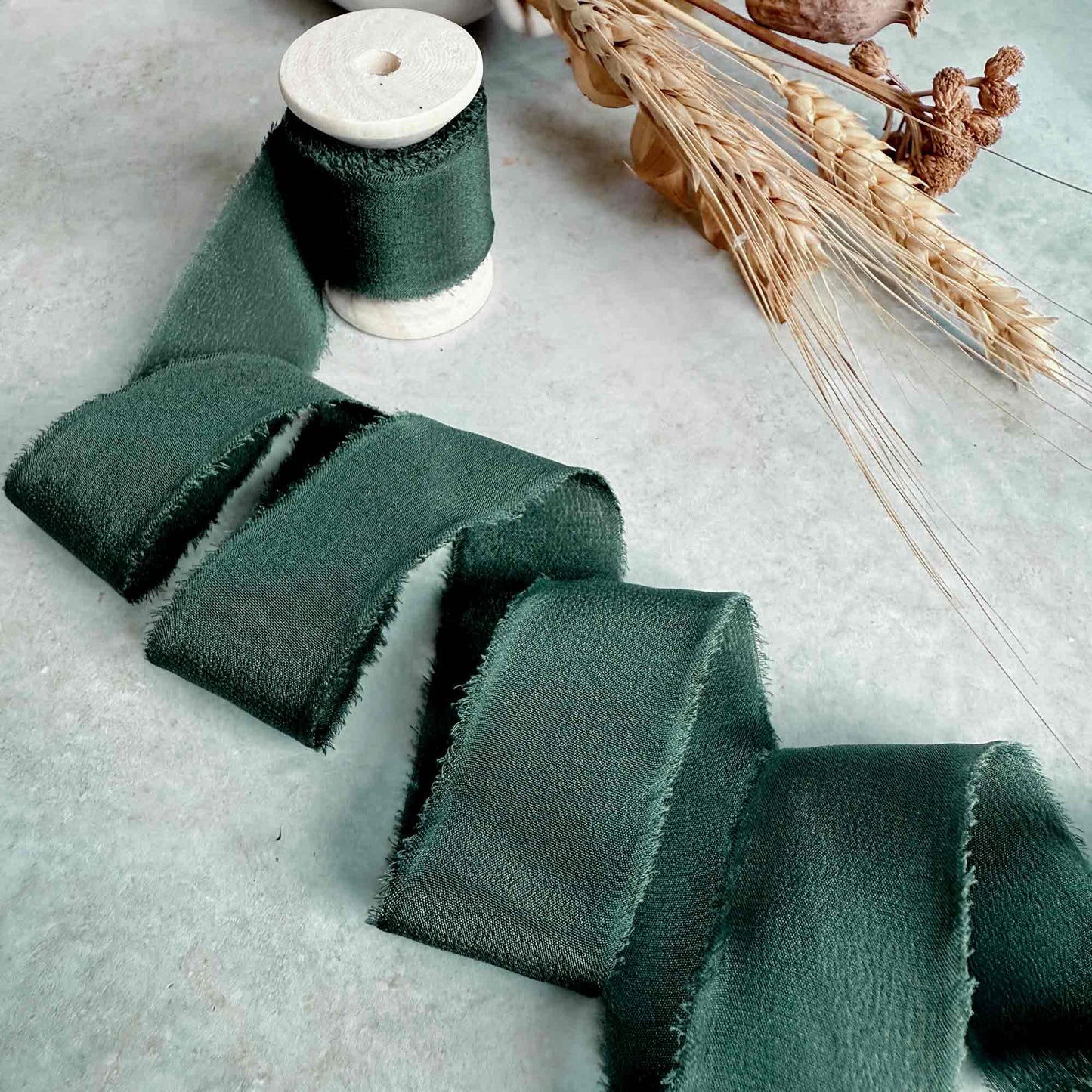 1 inch wide Frayed edge Silk ribbon in forest green.  Sold on a wooden reel