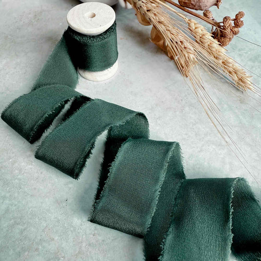 1 inch wide Frayed edge Silk ribbon in forest green.  Sold on a wooden reel