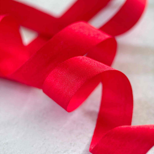 Close-up of Berry Red closed edge silk ribbon in a narrow 13mm width for weddings and luxury stationery.