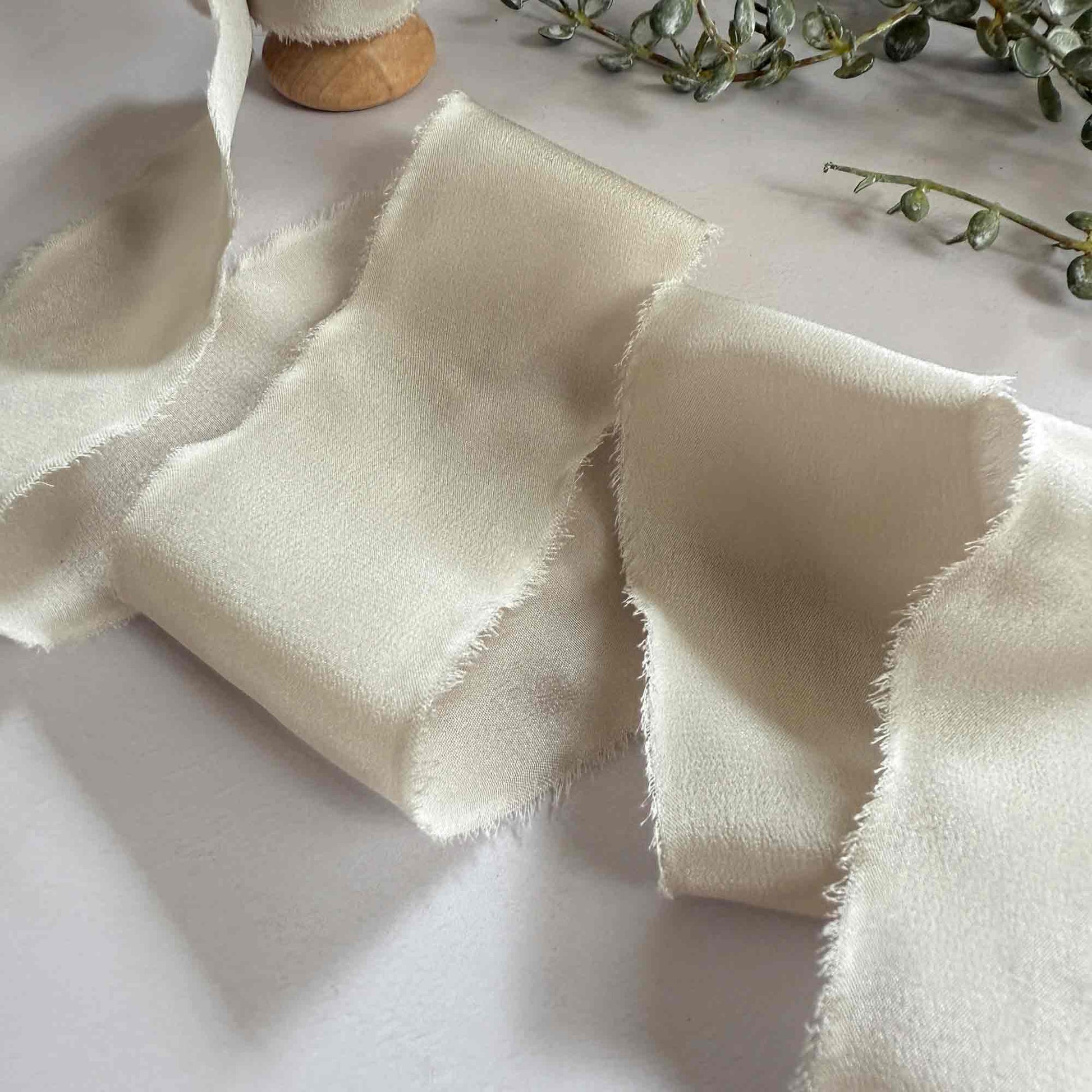 Wide silk ribbon with a frayed edge.