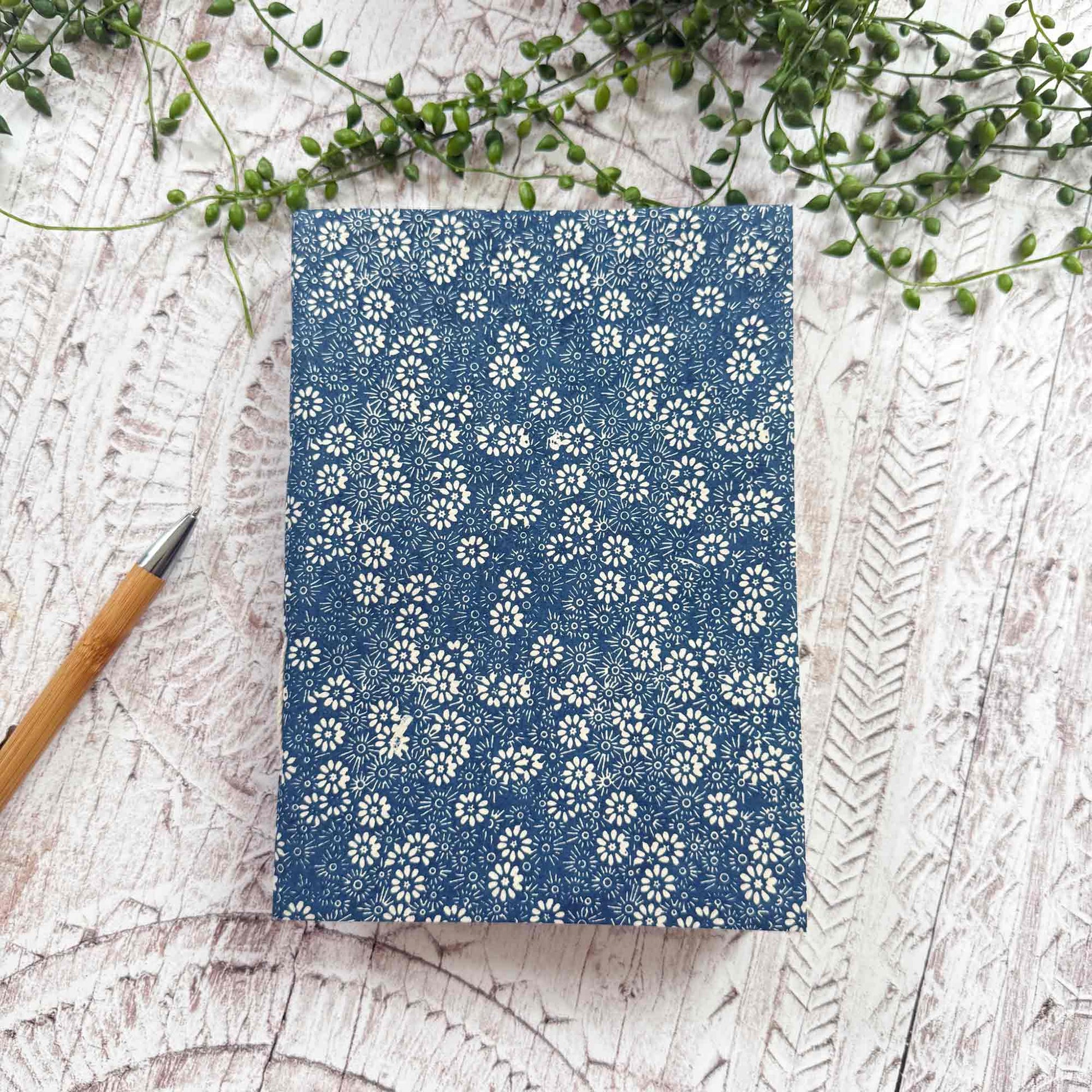 A5 Bellis Blue Lokta paper notebook by The Natural Paper Company. Handcrafted in Nepal from sustainable Lokta paper, with navy floral print and traditional hand‑stitched binding
