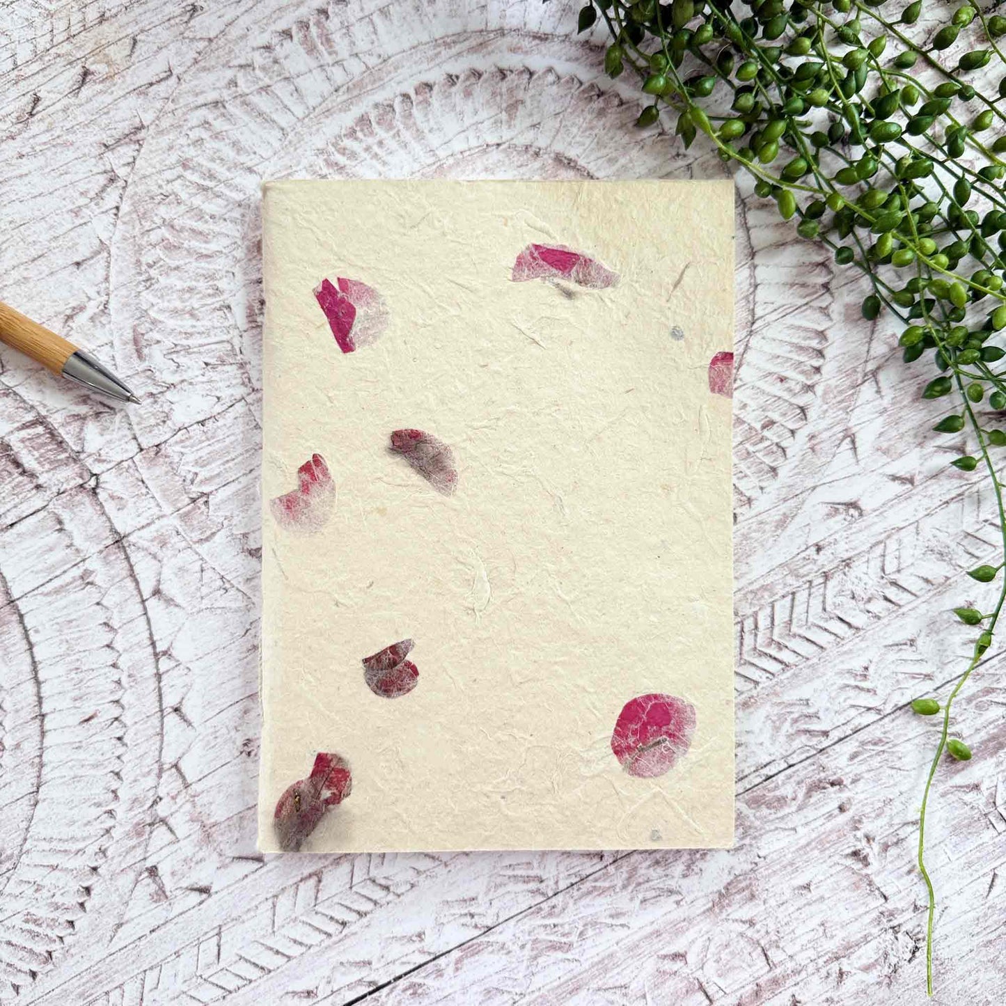 A5 botanical Lokta notebook, natural cream paper decorated with vibrant Bougainvillea petals, hand‑stitched and sustainably made in Nepal