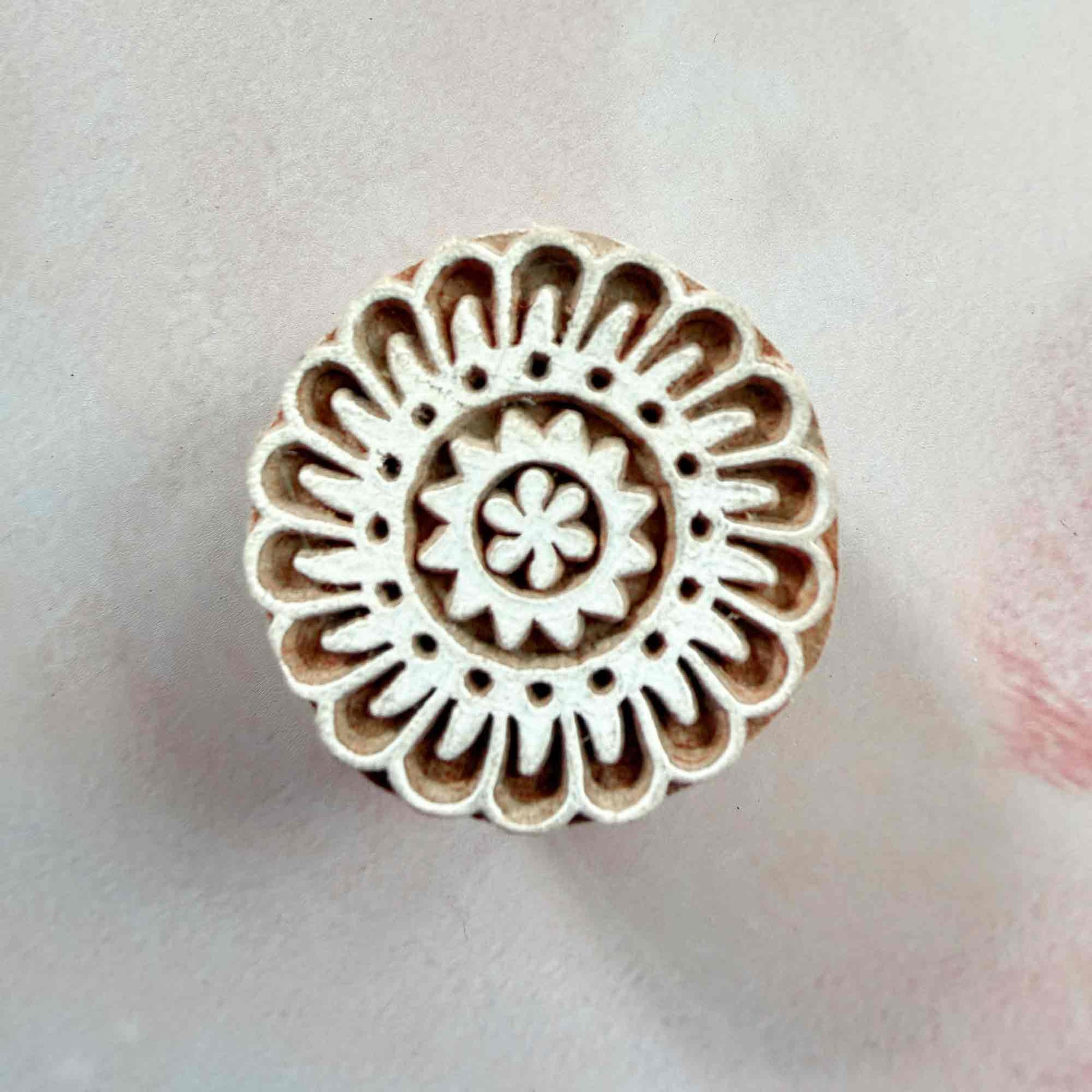 Corolla design wooden stamp — traditional hand-carved Indian printing block on pale background