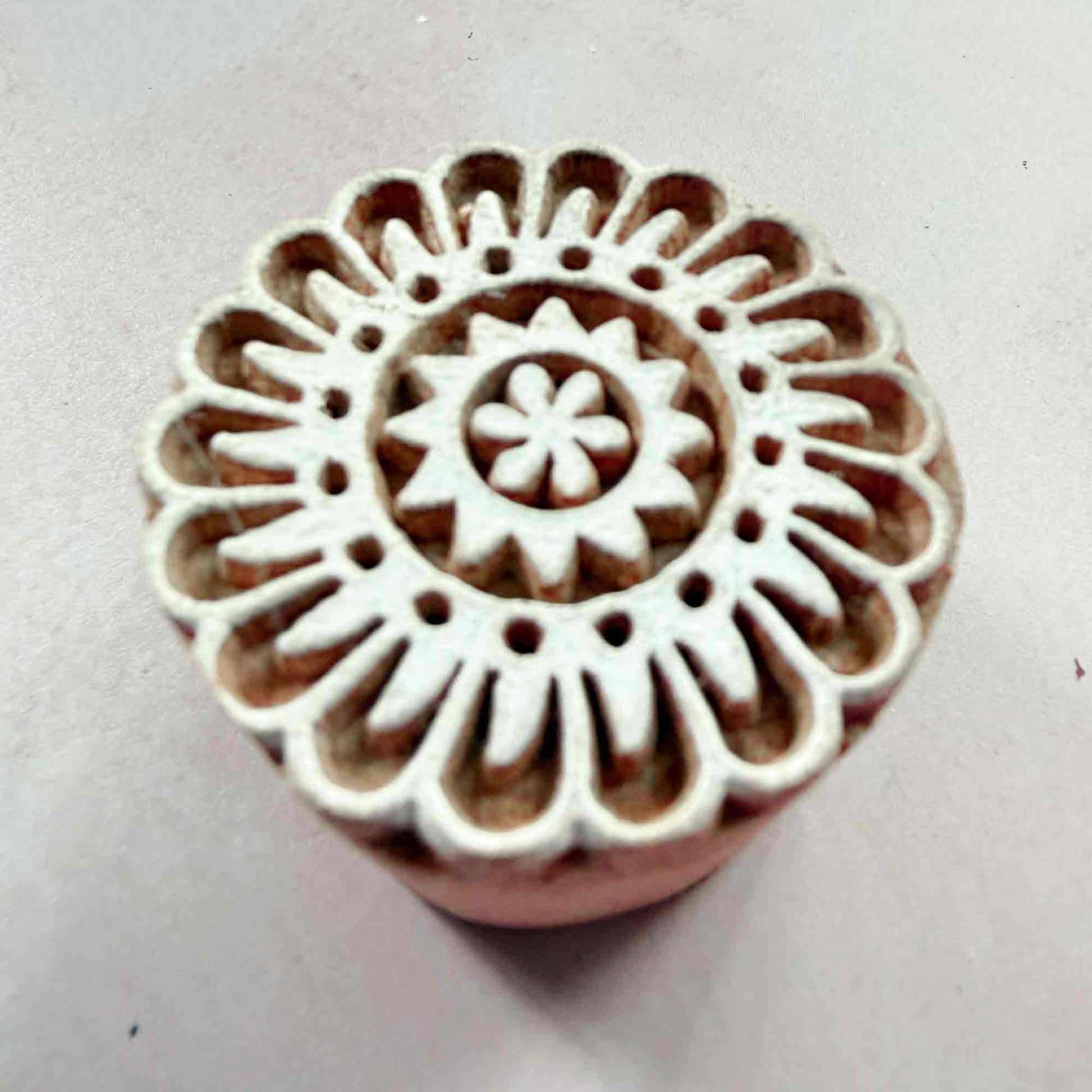 Hand-carved Corolla Indian wood block stamp, circular floral printing block close-up

