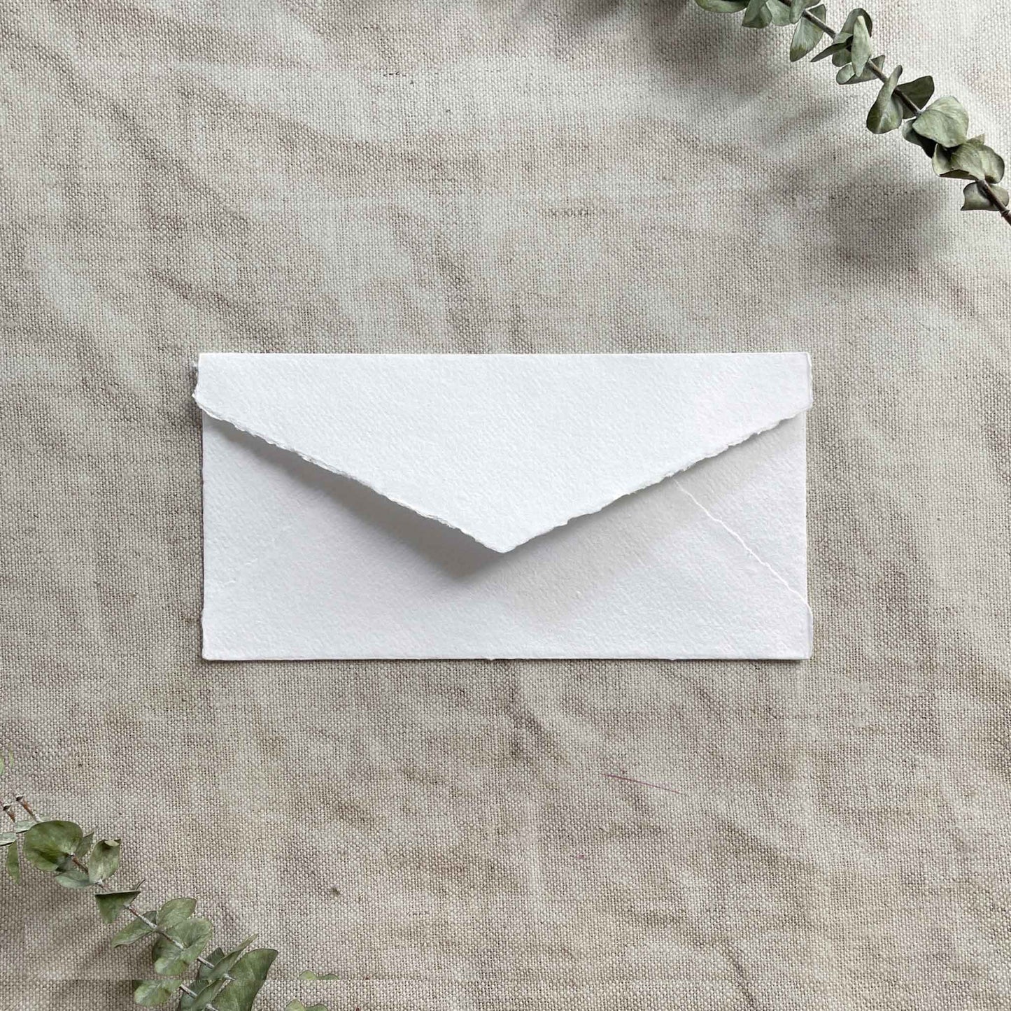 white handmade paper envelope with deckled edges.  White DL size