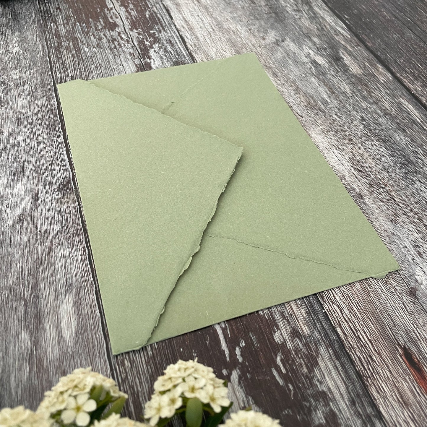 Sage green handmade paper envelope with a deckle edge pointed flap.  Made from recycled cotton rag paper.  By The Natural Paper Company