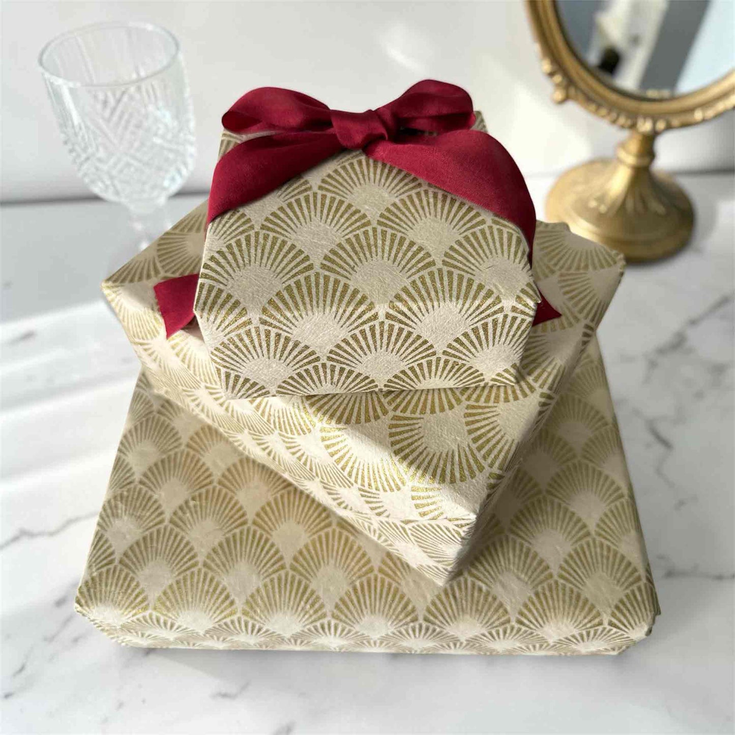 Handmade Lokta paper wrapping paper with gold Art Deco fan pattern, wrapped gift boxes with red ribbon, eco-friendly gift wrap