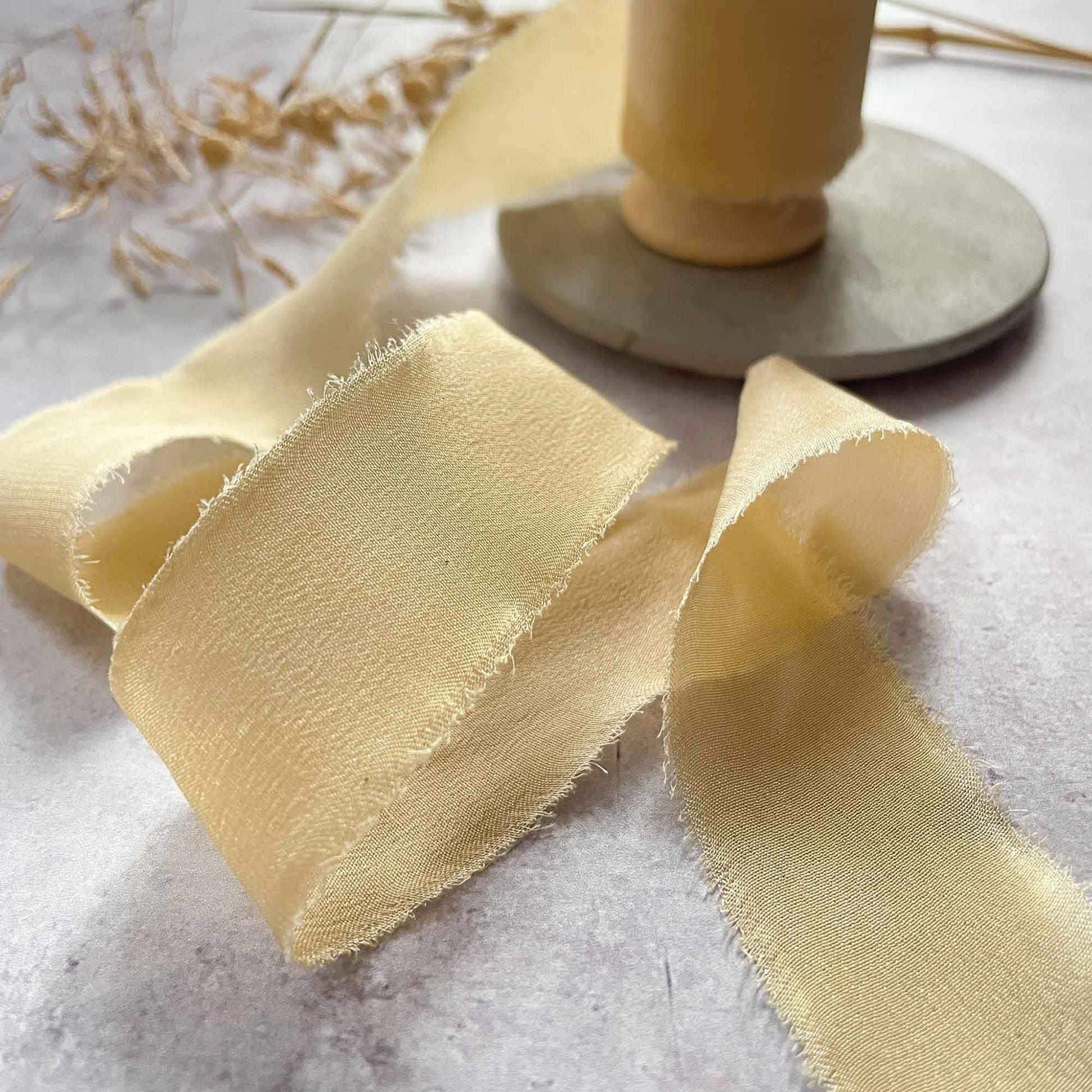 Fine silk ribbon in a lemon yellow colour.  Silk ribbon with a frayed edge for decorating stationery and crafts.  Habotai silk ribbon by The Natural Paper Company