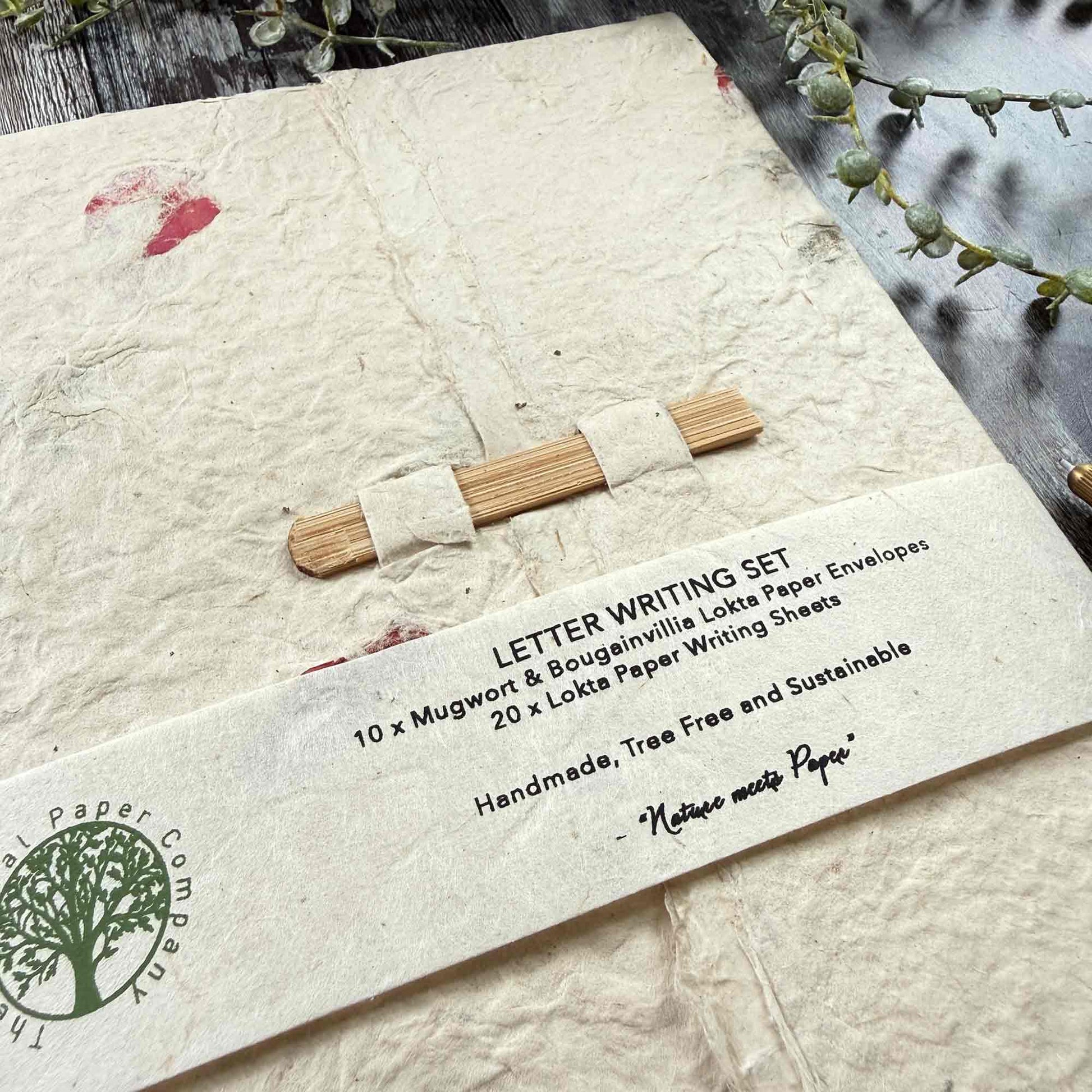 Front view of complete Lokta paper letter writing set, wrapped with branded label, tree-free sustainable paper, botanical design, bamboo closure