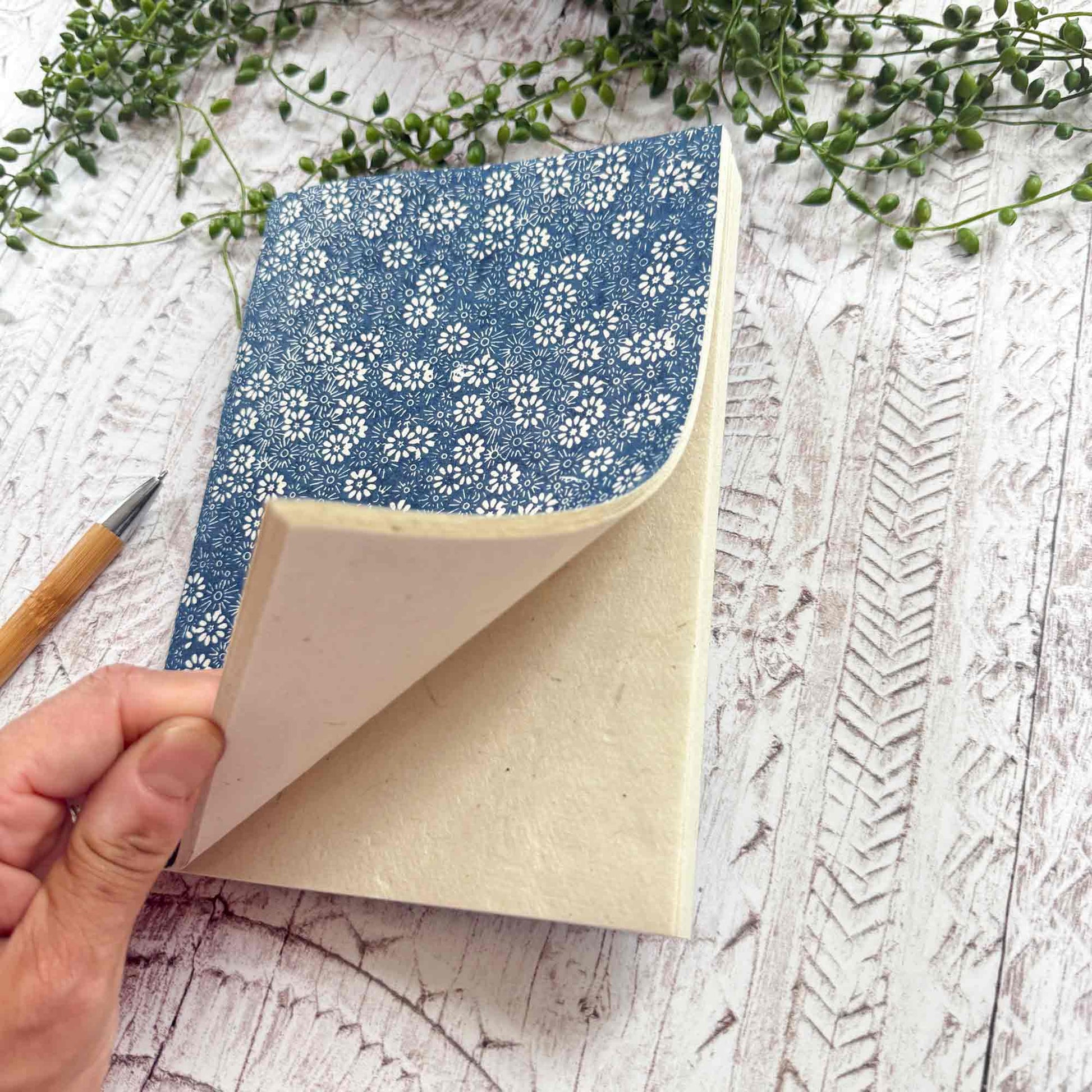 Open Bellis Blue Lokta paper notebook by The Natural Paper Company. Handmade in Nepal, revealing natural textured Lokta pages and hand‑stitched binding