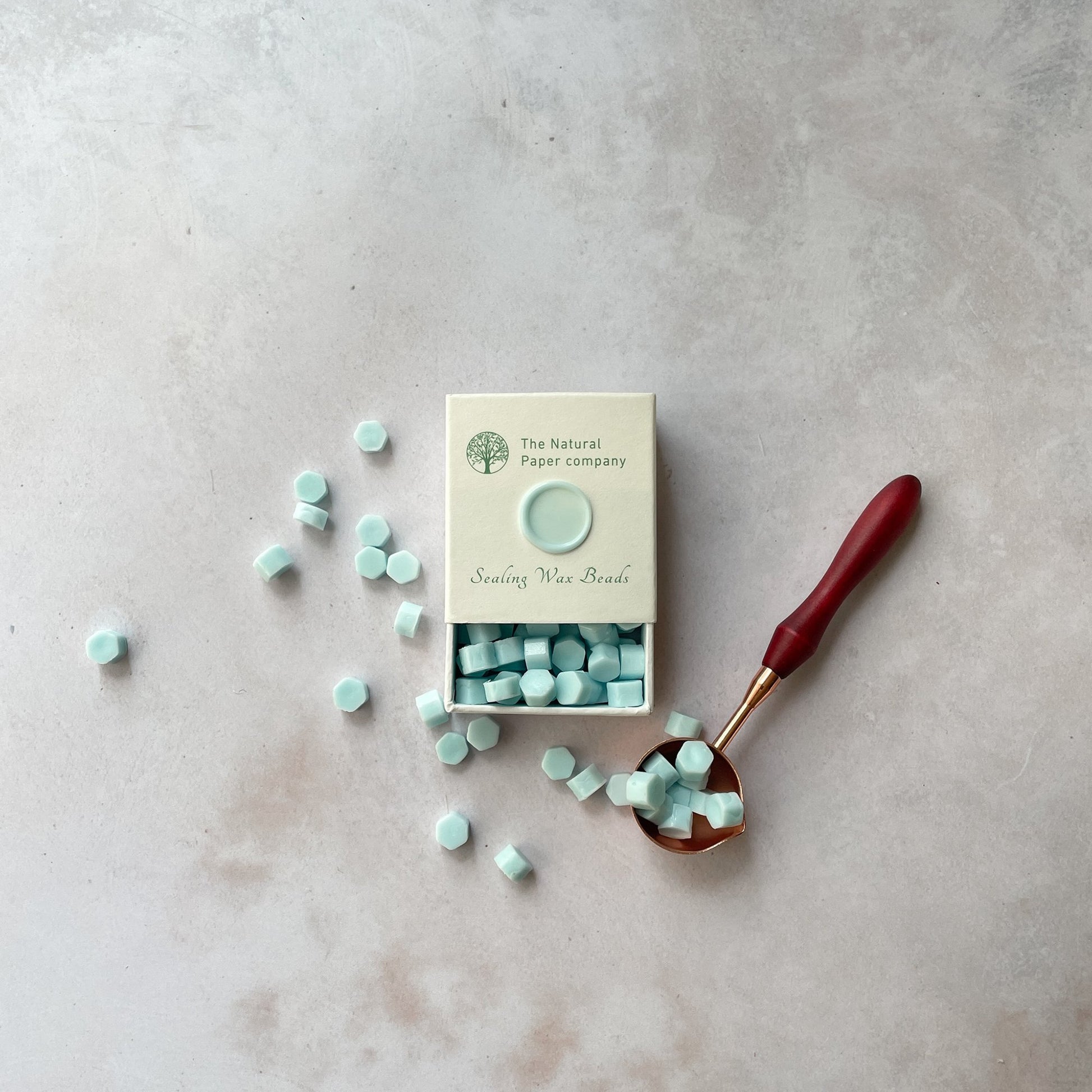 Aquamarine sealing wax beads in a box.  Eco friendly wax beads for making wax seals in Aqua.  By The Natural paper Company