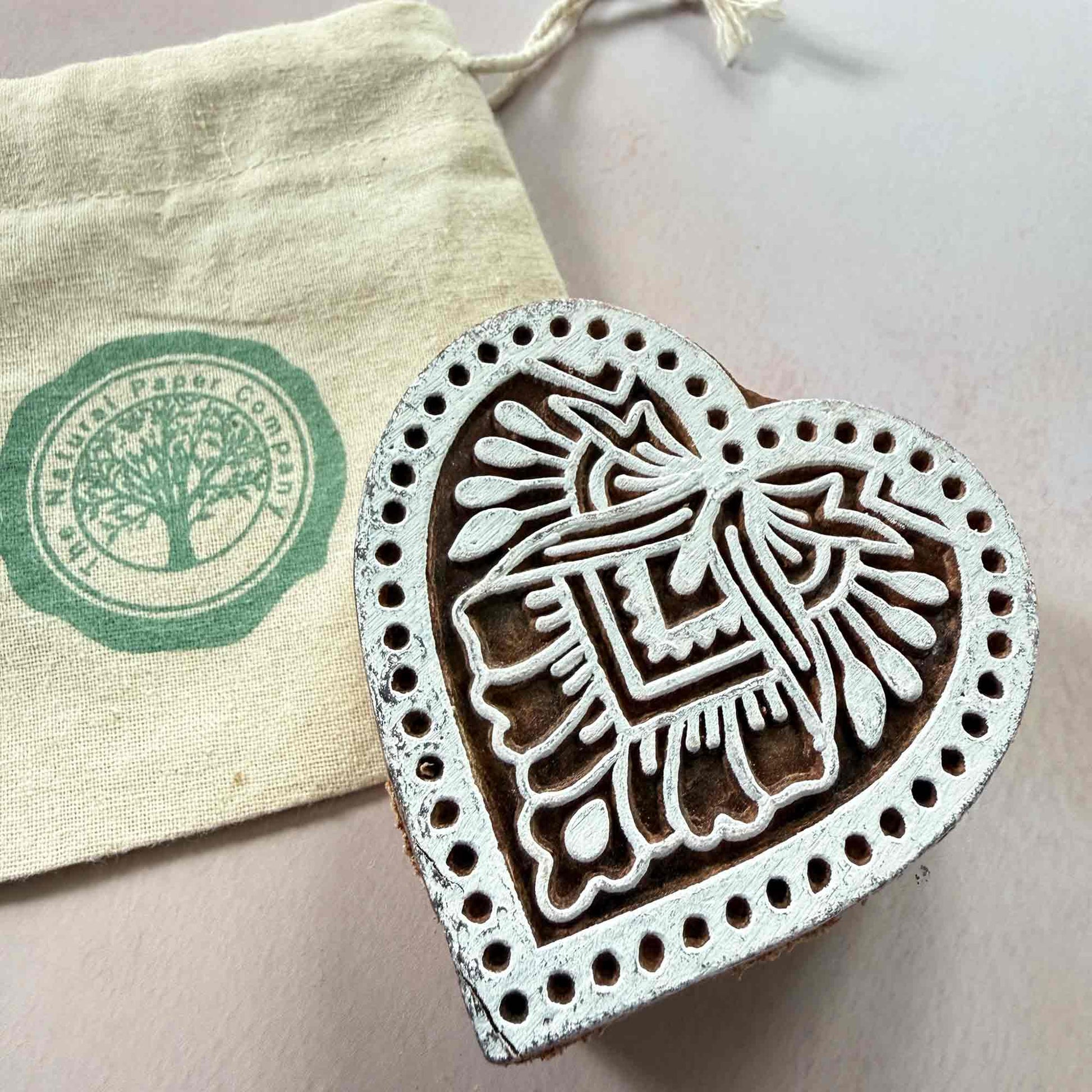 Heart-shaped wooden stamp with branded gift bag