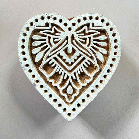Heart-shaped decorative stamp with intricate patterns 