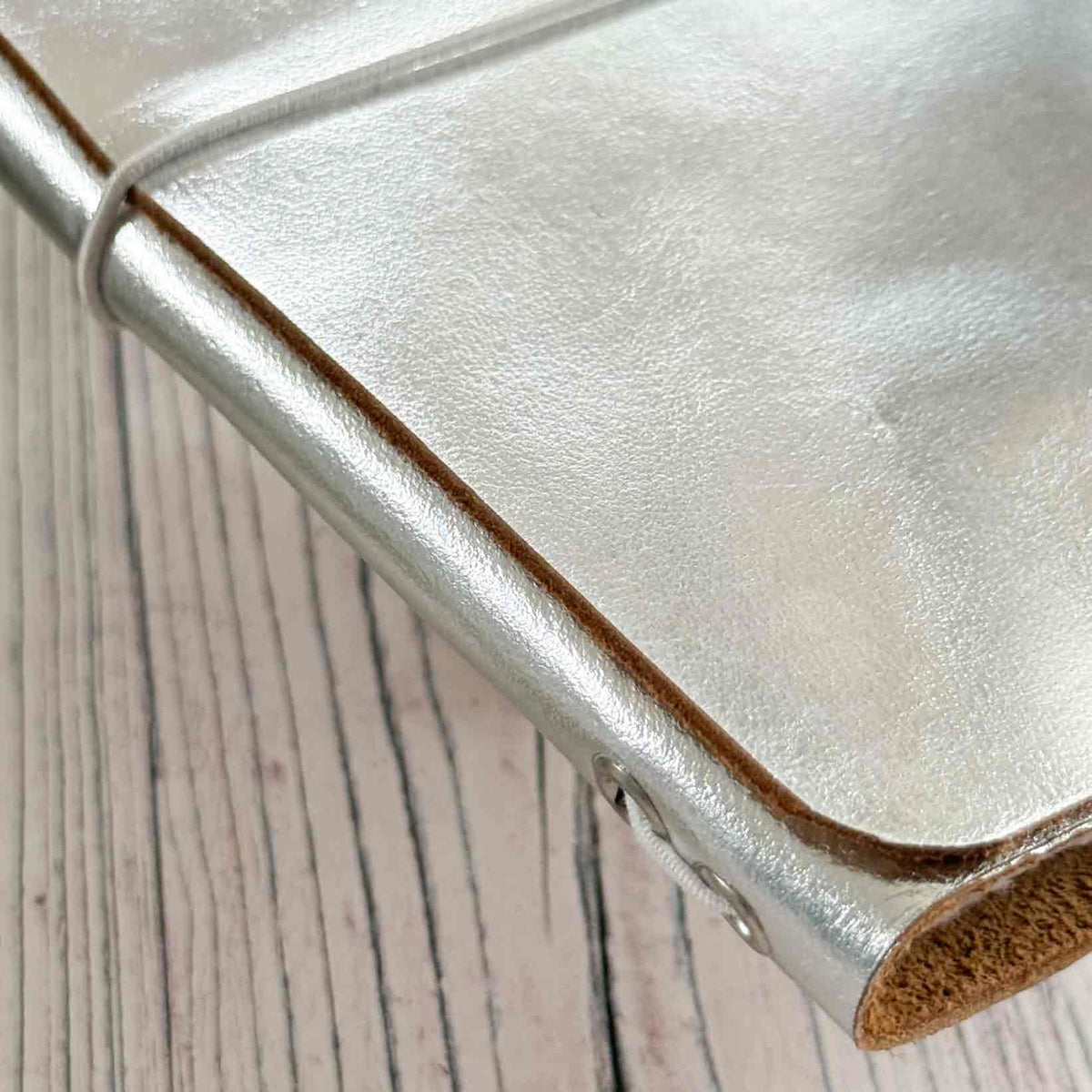 Close-up of metallic silver genuine leather refillable journal cover and elastic closure
