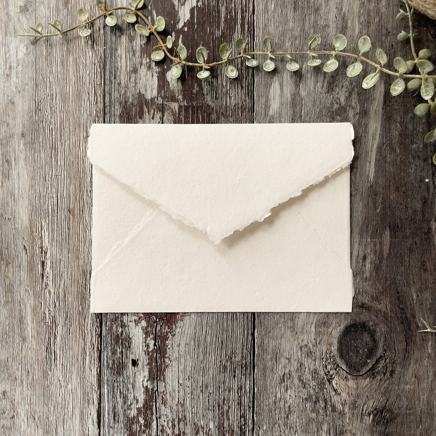 White handmade paper envelope made from recycled cotton rag paper with a deckled edge.  By The Natural paper Company