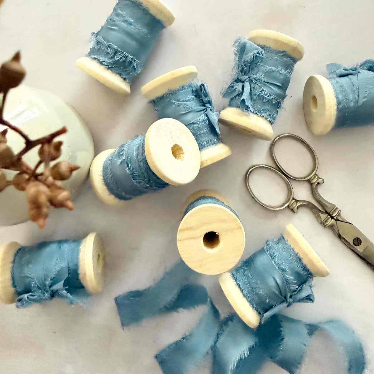 Airforce Blue 10mm raw edge silk ribbon displayed on wooden reels