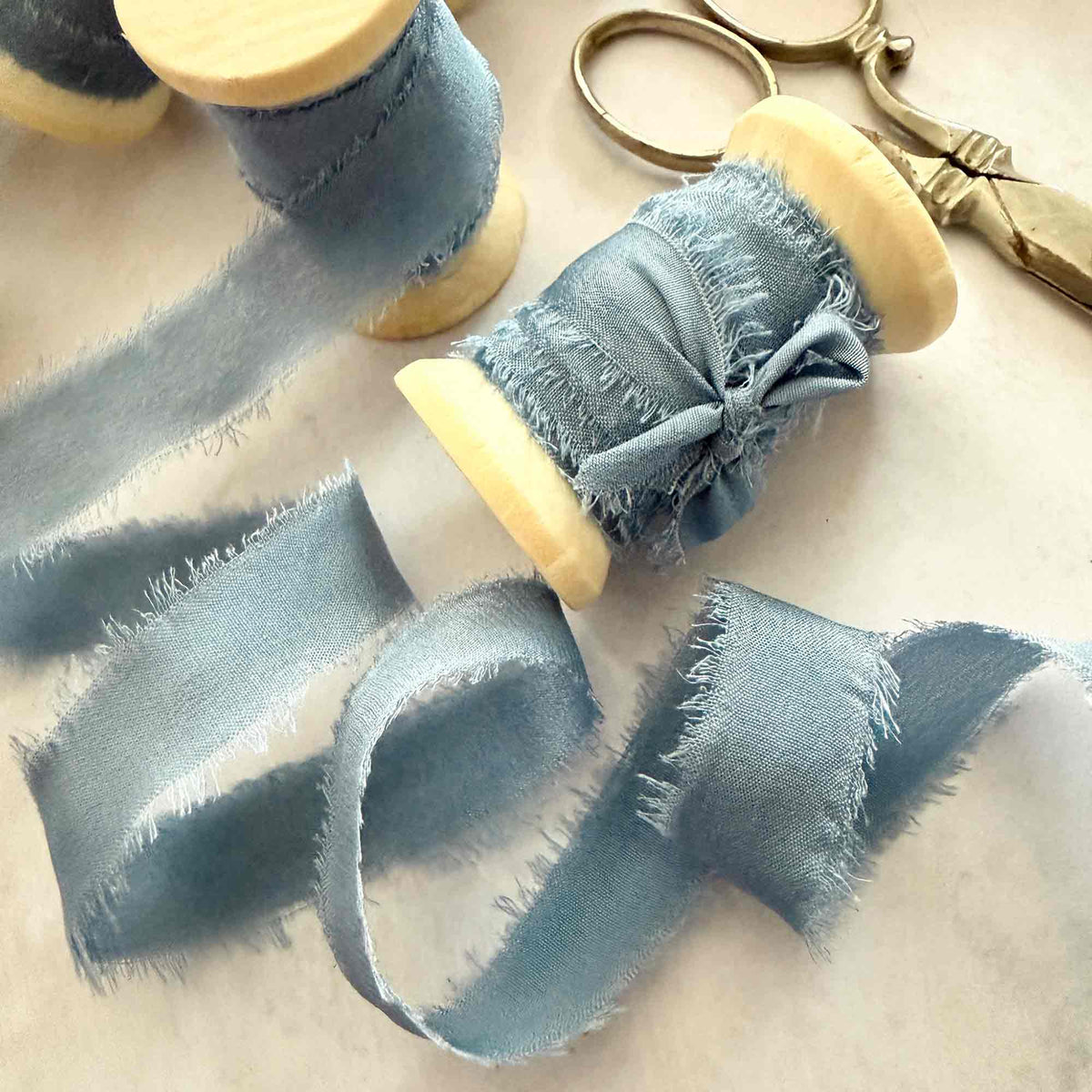 Airforce Blue Habotai silk ribbon with frayed edges on wooden reel