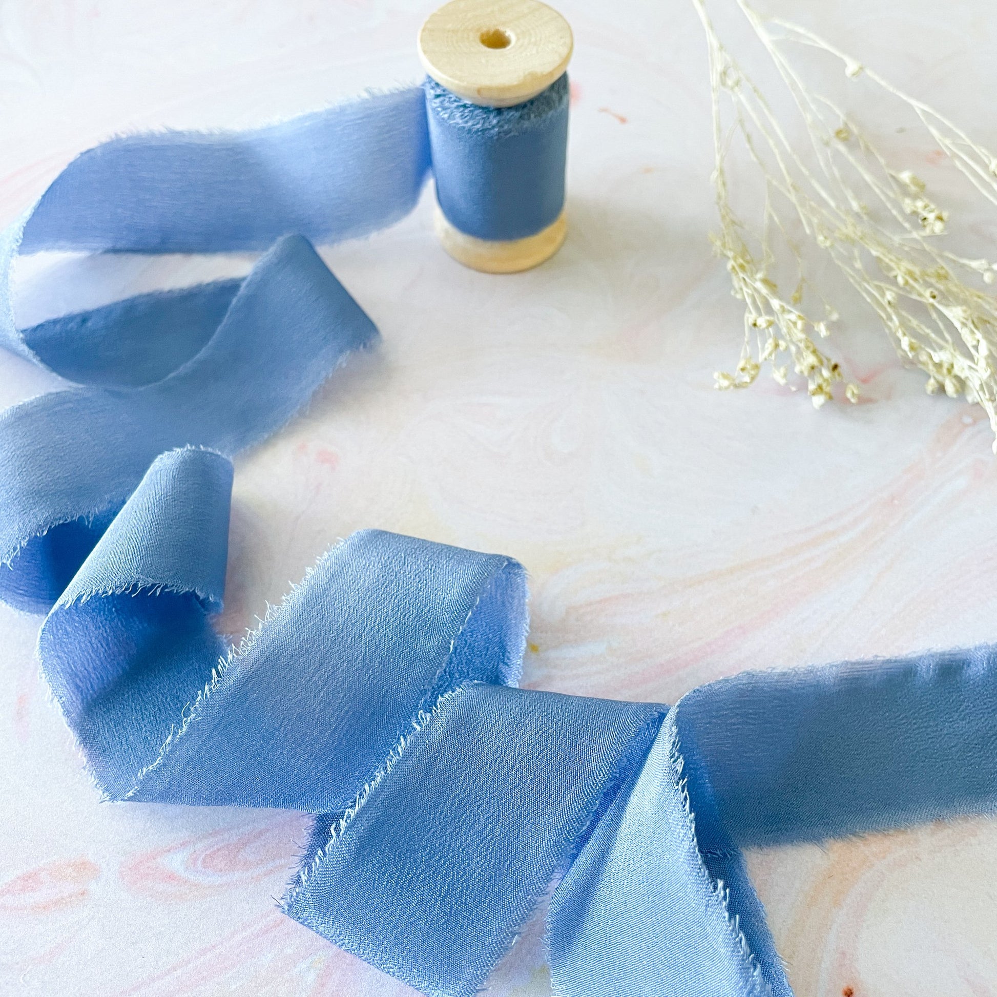 Cornflower blue silk ribbon with a raw edge.  Decorative habotai silk ribbon for crafts.  By The Natural Paper Company.