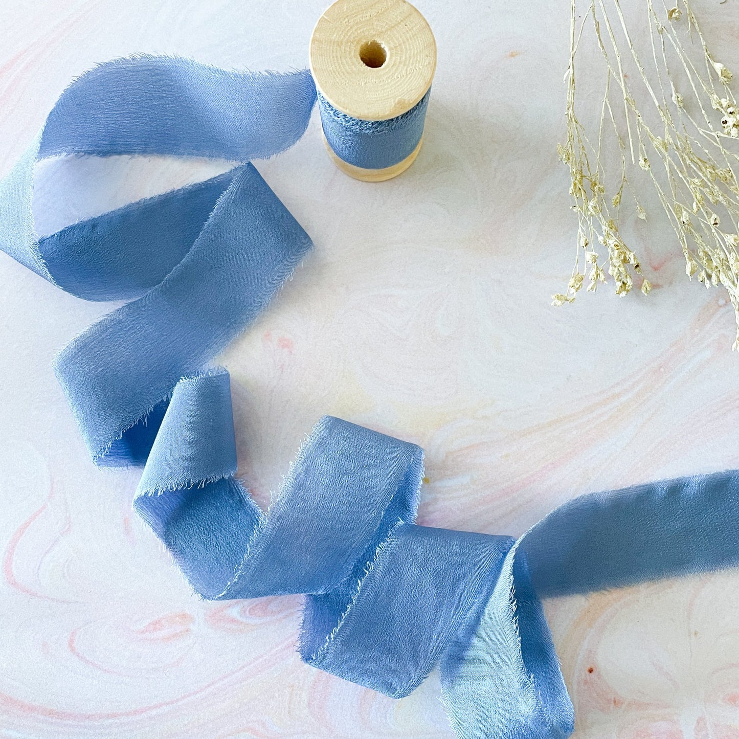 Luxury silk ribbon in blue.  Fine silk ribbon on a wooden reel.  By The Natural Paper Company.