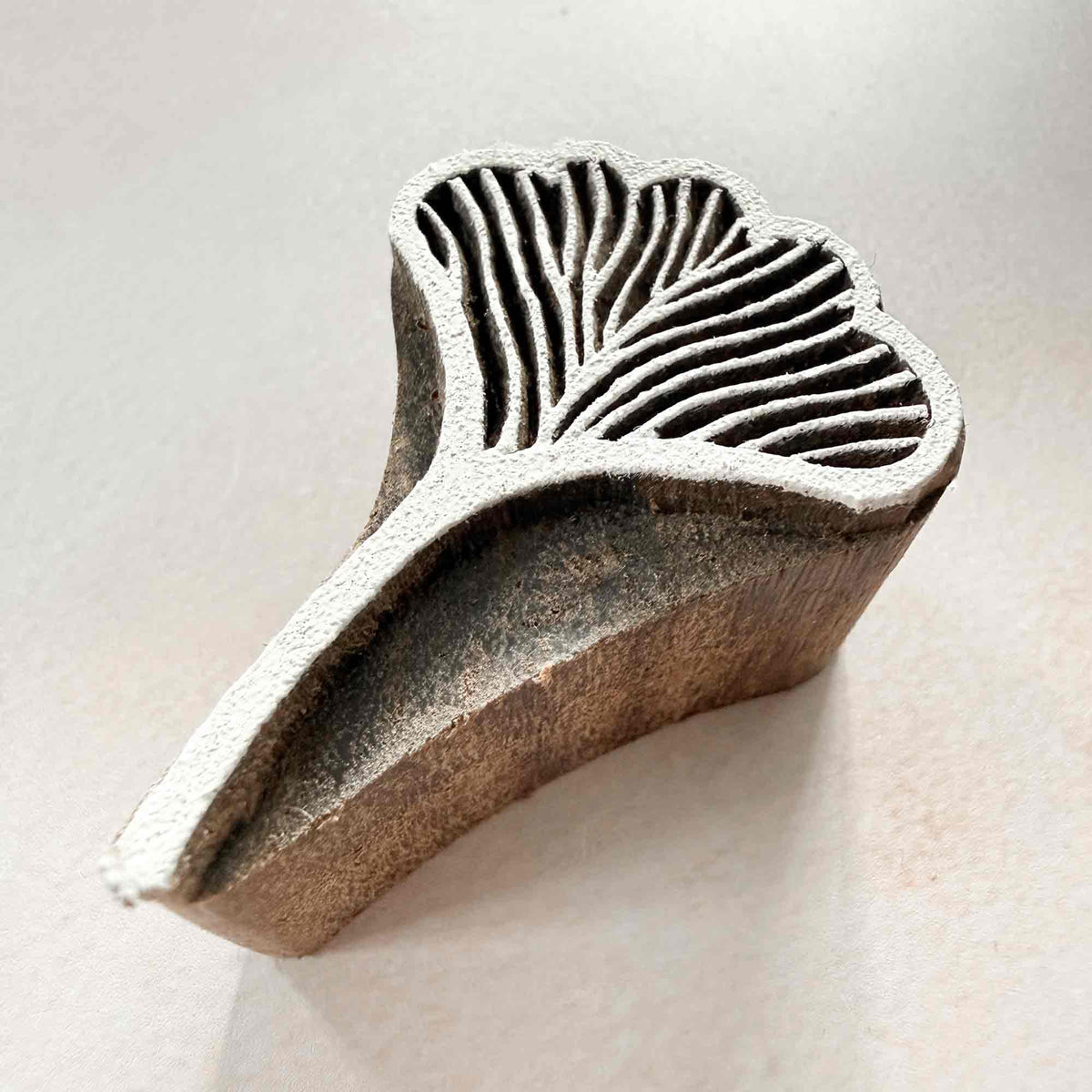 Hand-carved Alaria botanical wooden stamp with flowing stem and seaweed-inspired pattern