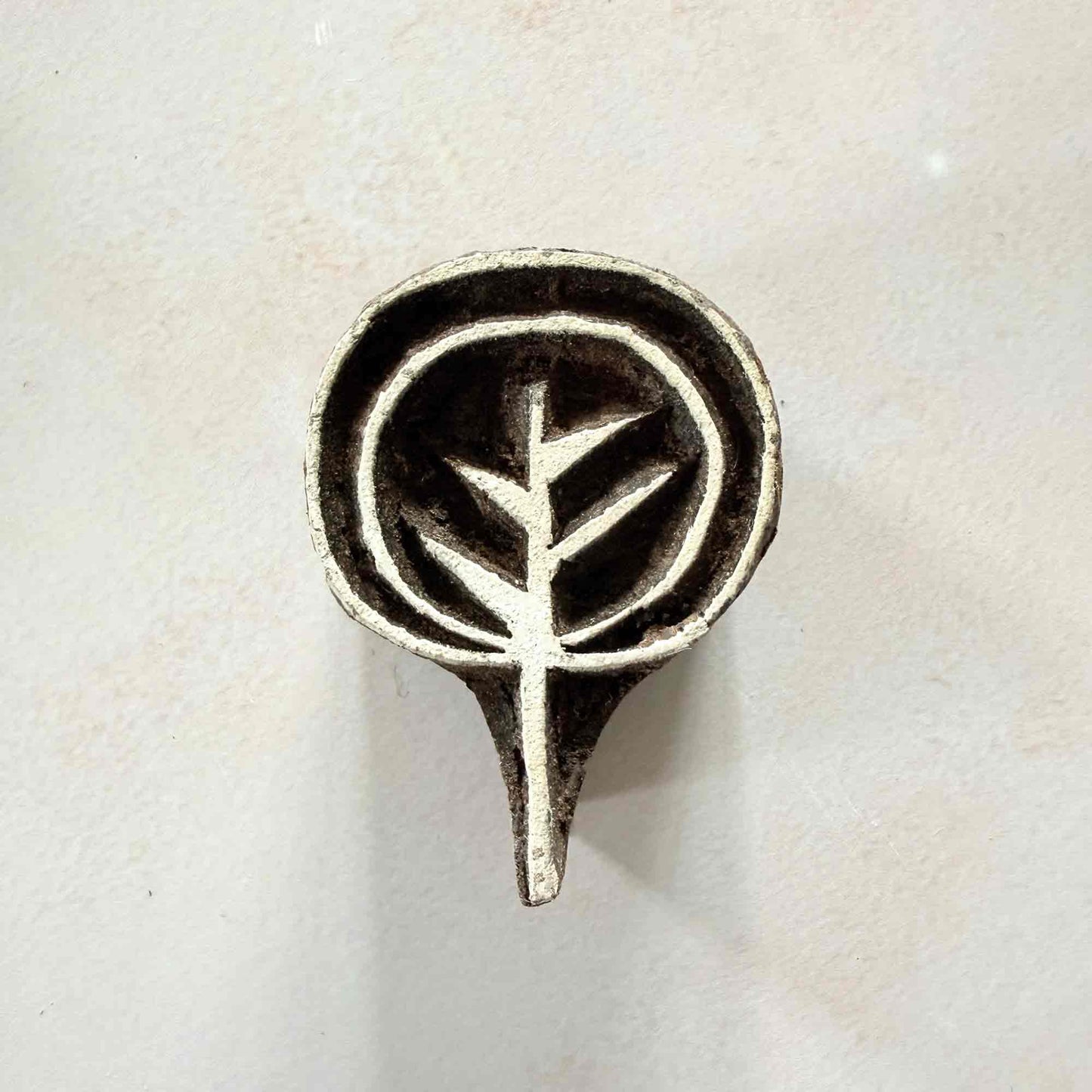 Ankur botanical Wooden Stamp with a stylised leafy sprig inside a rounded hand-carved frame.