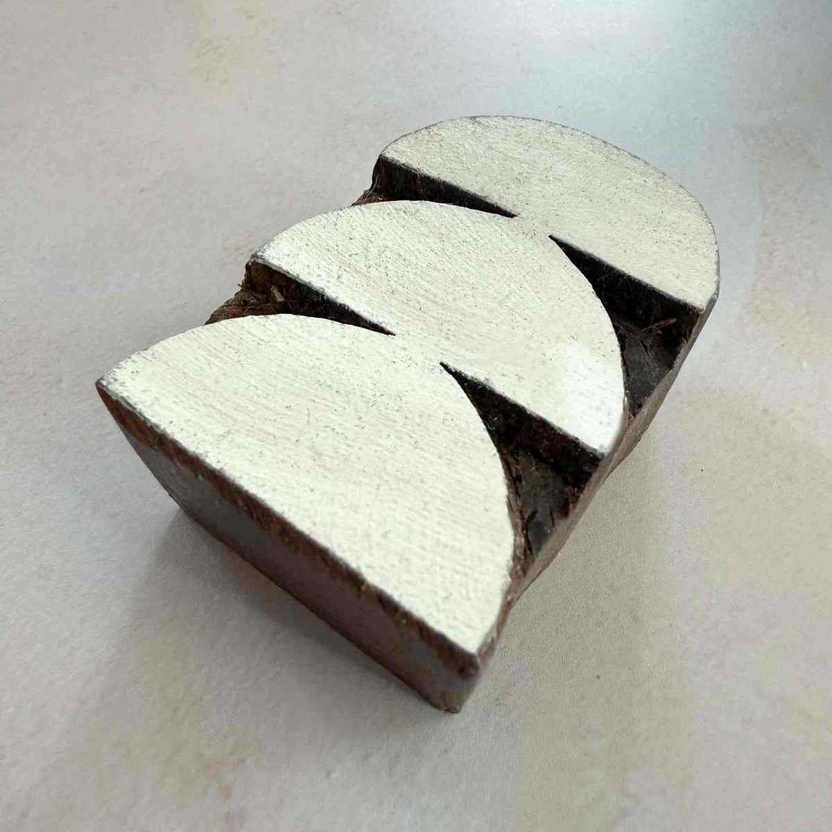 Angled view of Arches geometric wooden printing block featuring three overlapping broad curved shapes.