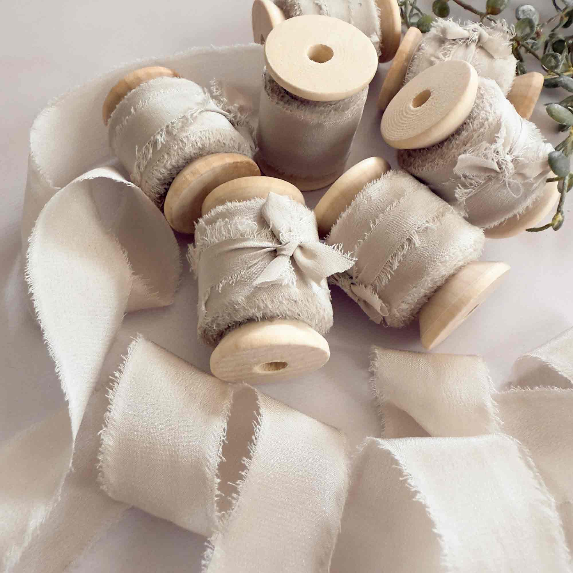 Neutral beige silk ribbon on a wooden reel.  Putty colour silk