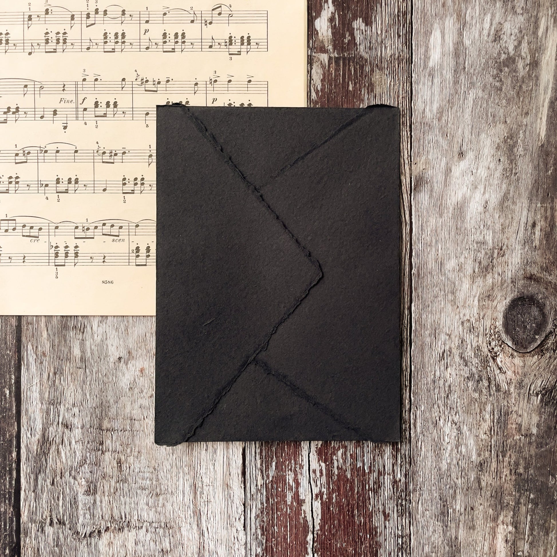 Black envelope made from handmade paper.  Invitation envelope with deckled edges and a pointed flap.  Made from recycled cotton rag fibres.  By The Natural paper Company