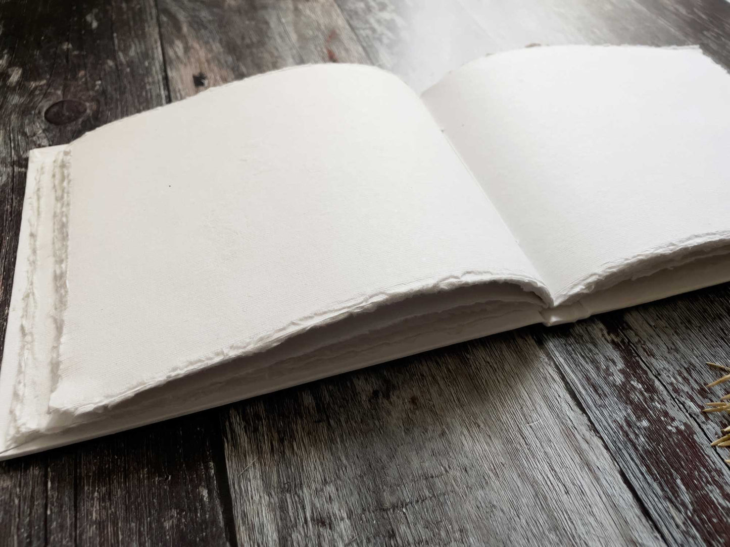 White blank notebook made from handmade cotton rag paper with deckled edges.  50 pages.  Hard cover.  Perfect for making wedding guest books, journals and personalised notebooks.  Can also be used as an artists watercolour book.  By The Natural Paper Company