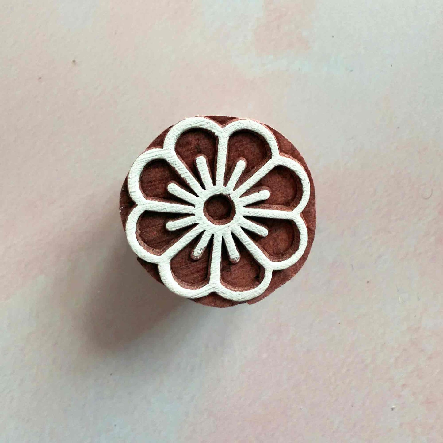 A small wood block stamp with a flower design.  Add a pretty floral pattern to your cards, gift wrapping or fabric
