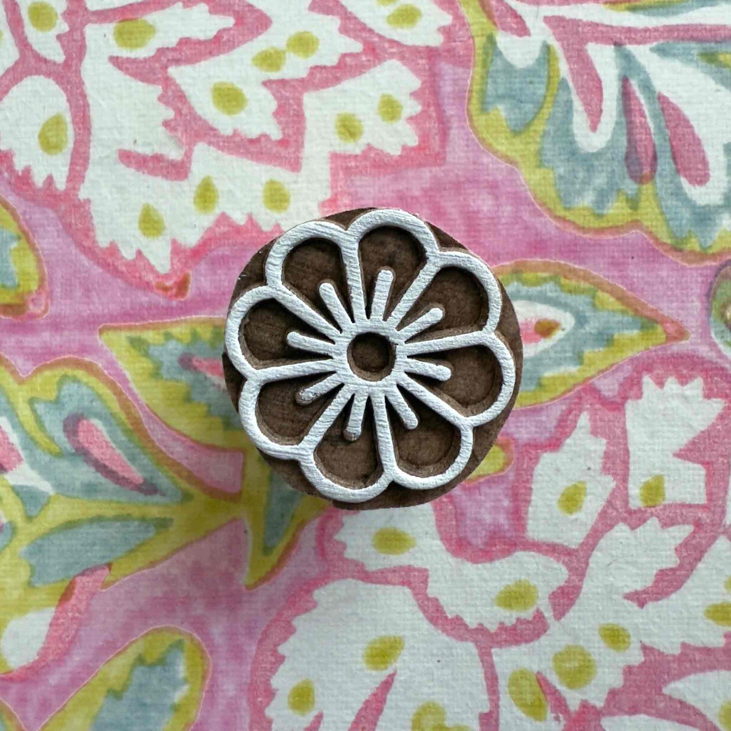 small wood block stamp with a flower design.