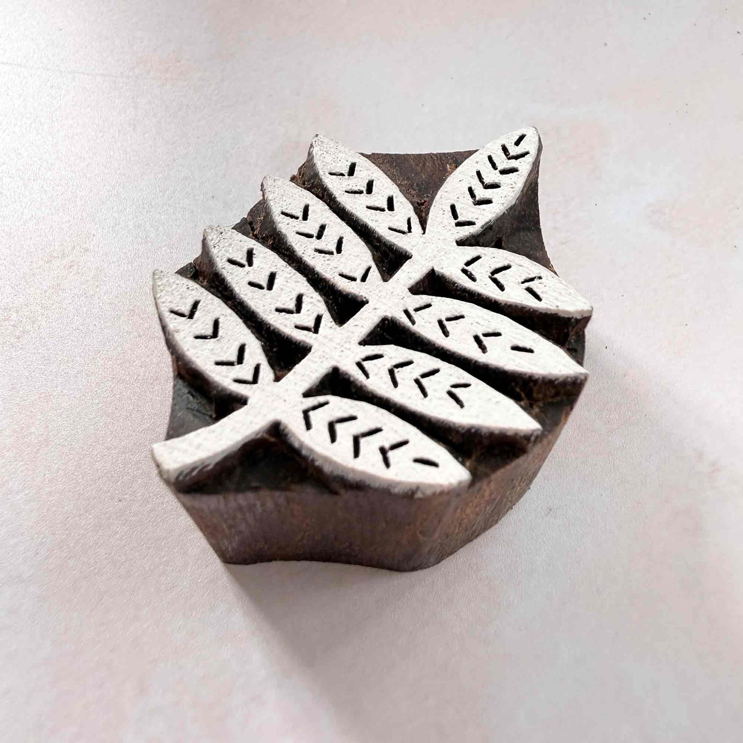 Indian wood block stamp — Bough leafy branch viewed from angle, showing carved depth and chevron vein texture, handcrafted wooden stamp, authentic traditional printing block from India