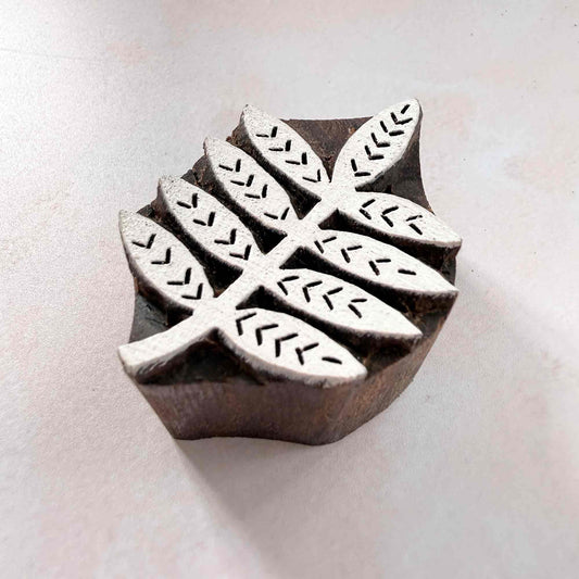 Indian wood block stamp — Bough leafy branch viewed from angle, showing carved depth and chevron vein texture, handcrafted wooden stamp, authentic traditional printing block from India