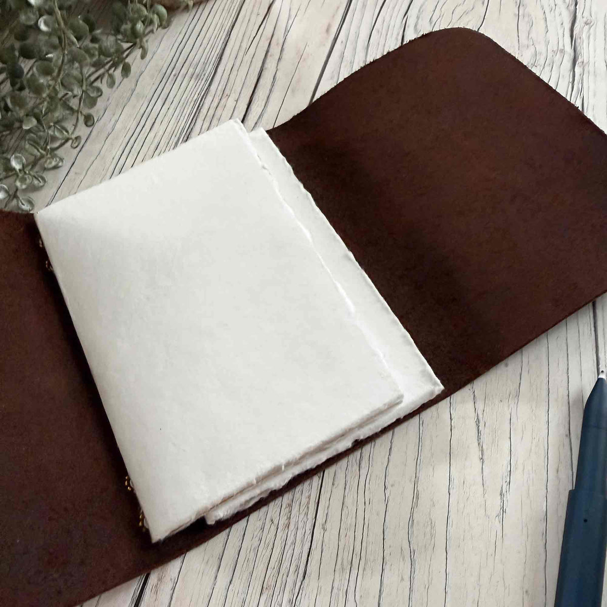 Open brown A6 refillable leather journal with handmade cotton paper inserts