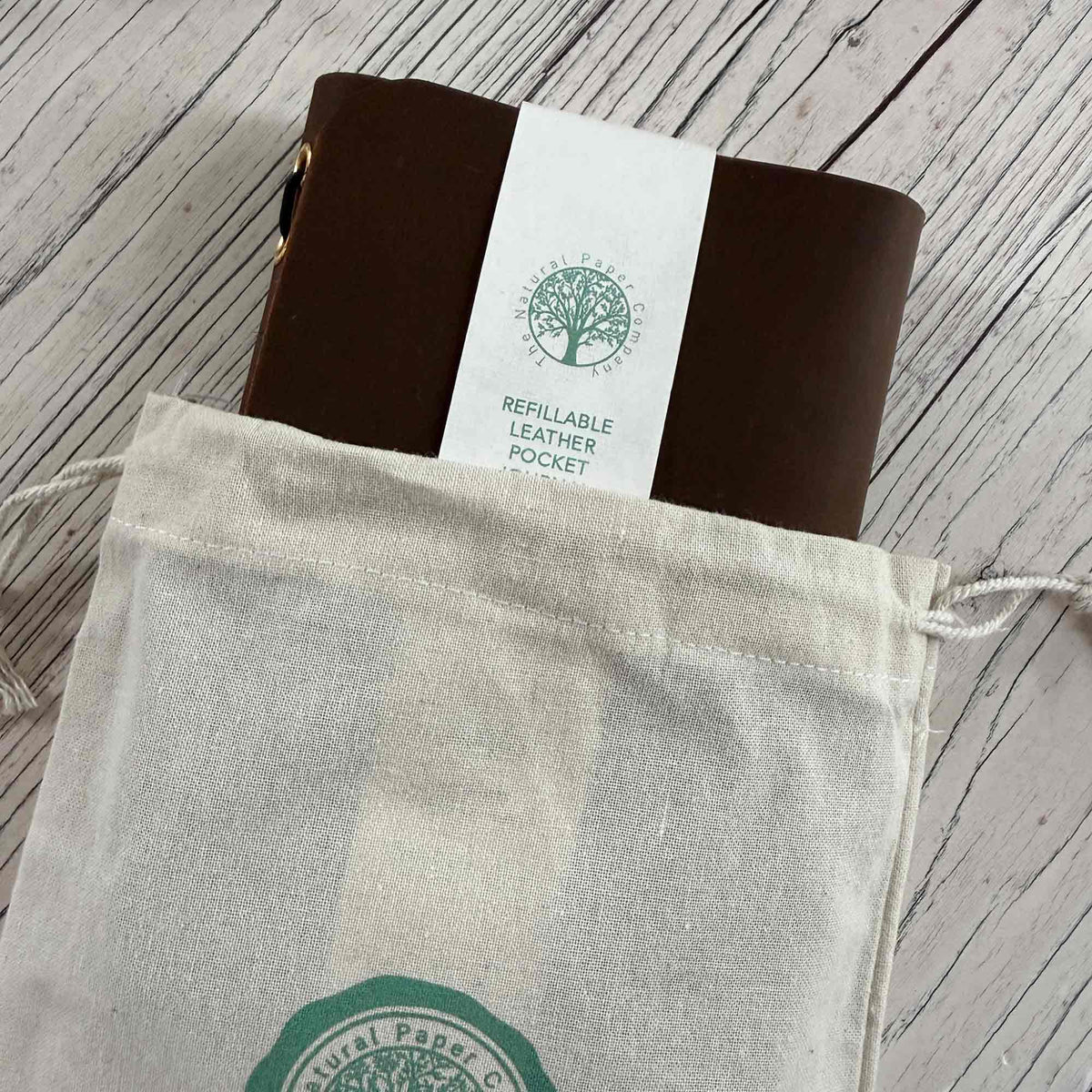 Brown A6 refillable leather journal presented with soft cotton gift bag