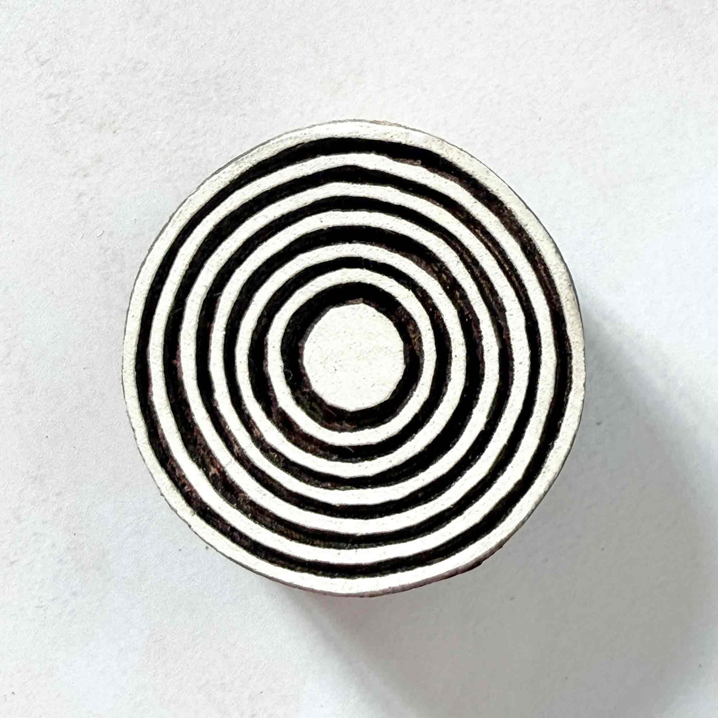 Indian wood block stamp — Bullseye Medium design, seven wide concentric circles face-on view on soft pale background, symmetrical ring motif hand-carved wooden stamp, authentic traditional printing block from India