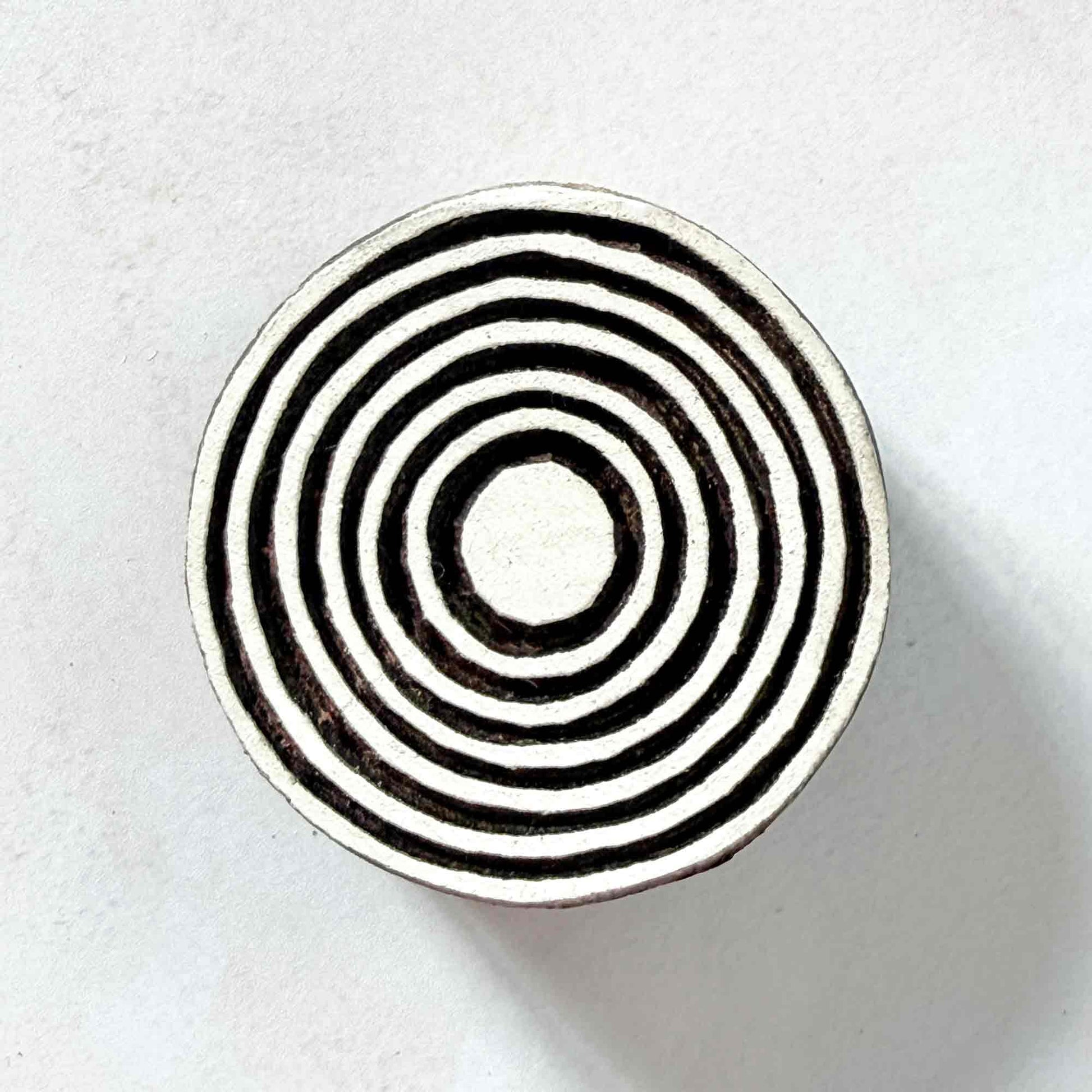 Indian wood block stamp — Bullseye Medium design, seven wide concentric circles face-on view on soft pale background, symmetrical ring motif hand-carved wooden stamp, authentic traditional printing block from India