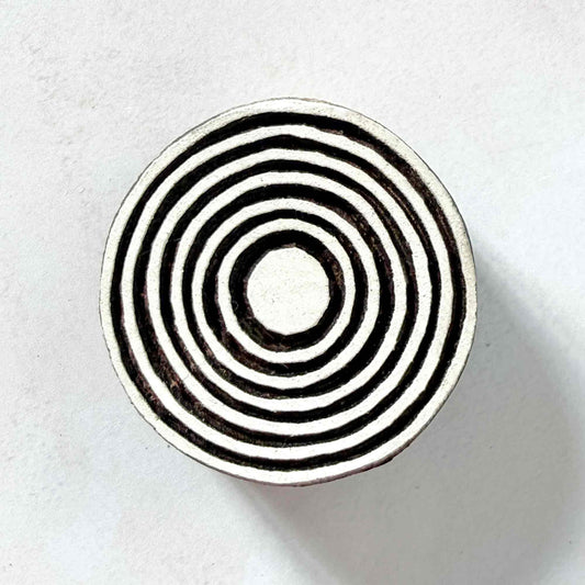 Indian wood block stamp — Bullseye Medium design, seven wide concentric circles face-on view on soft pale background, symmetrical ring motif hand-carved wooden stamp, authentic traditional printing block from India