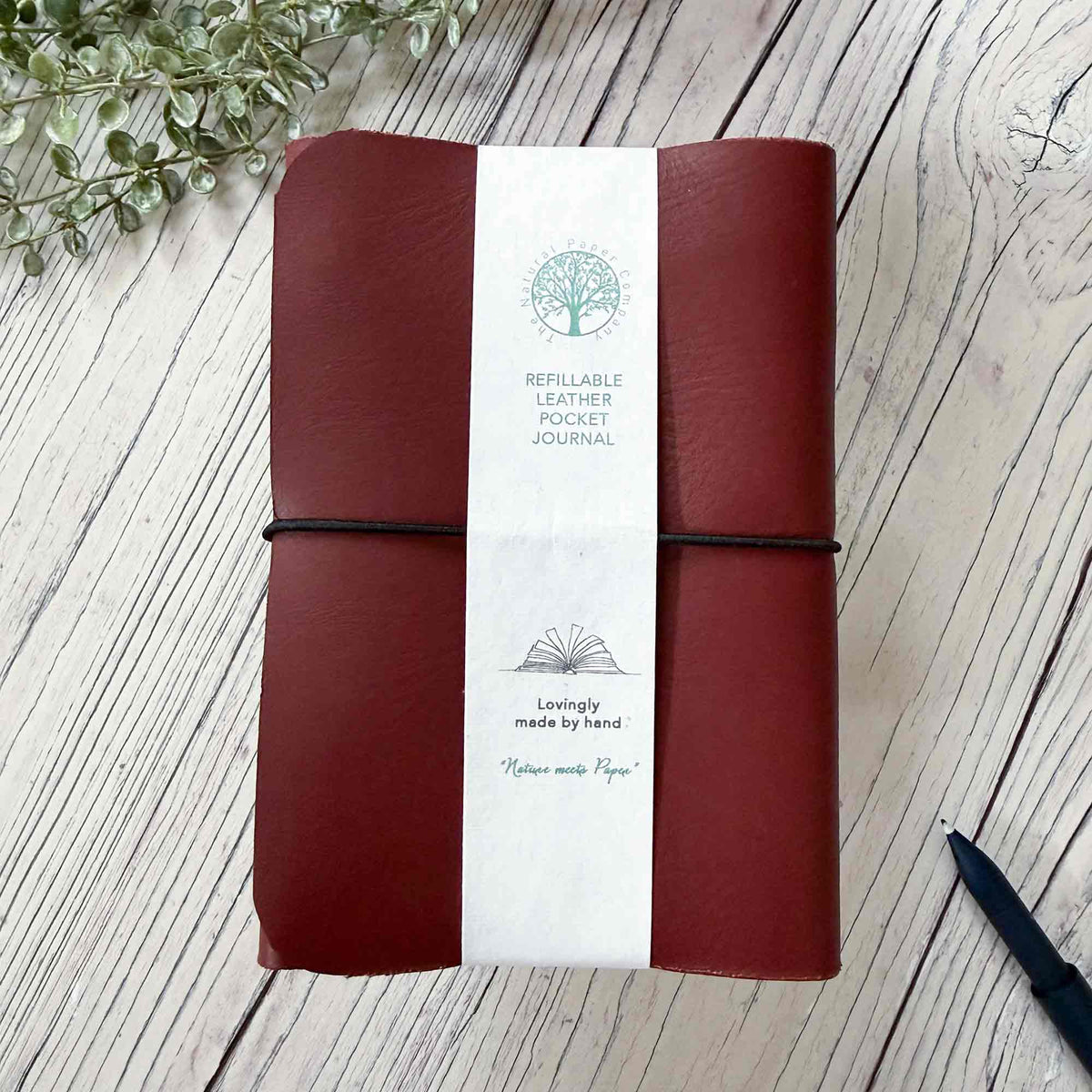 Handmade burgundy A6 refillable leather journal with contrasting black elastic closure