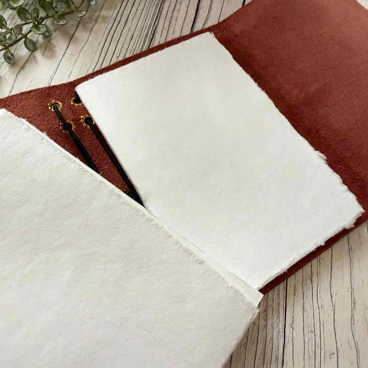 Burgundy A6 refillable leather journal showing removable handmade cotton paper inserts