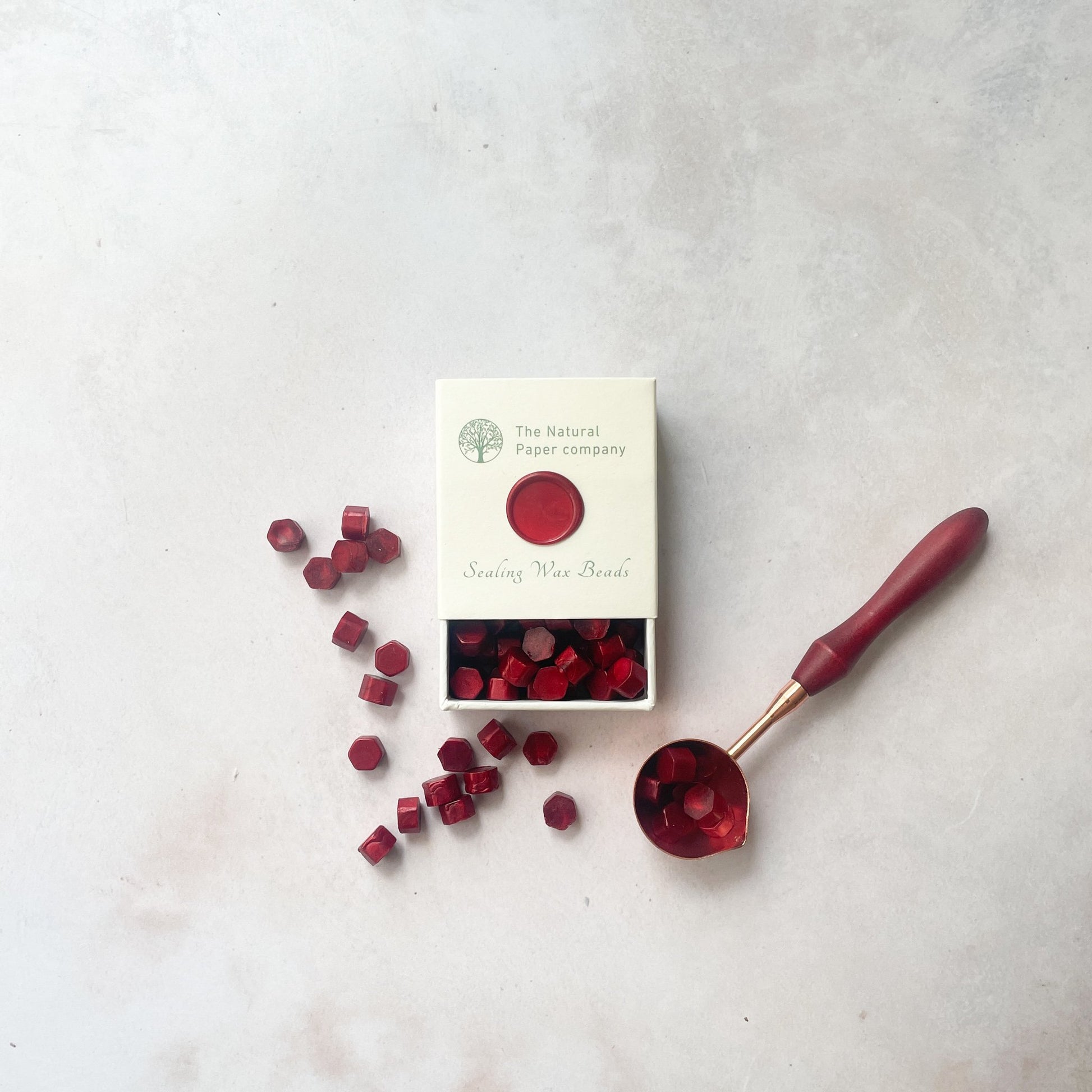 Burgundy sealing wax beads to make wax seals with a melting spoon.  Small box of eco friendly wax beads.  By The Natural paper Company