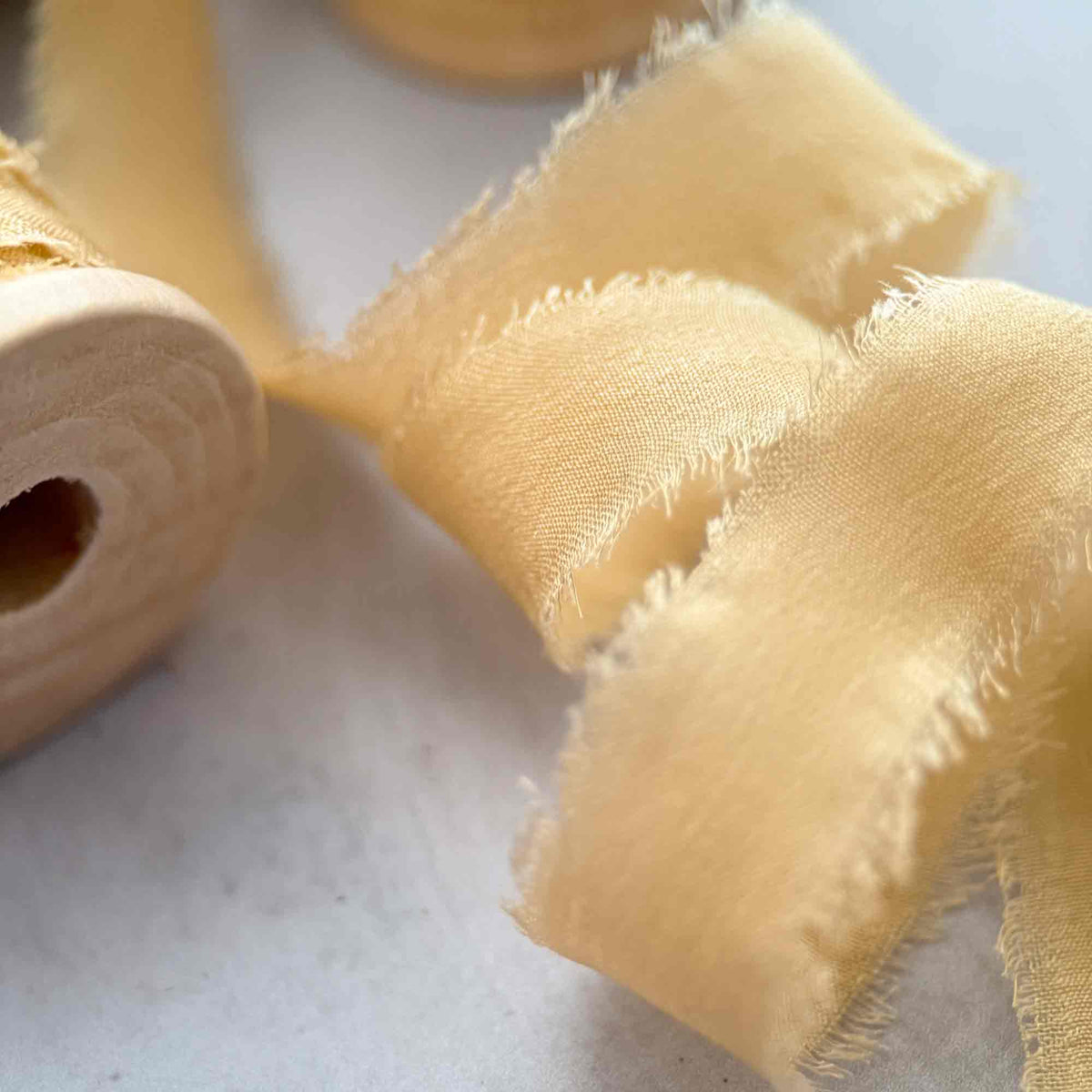 Close-up of Buttermilk 10mm Habotai silk ribbon showing soft raw edges