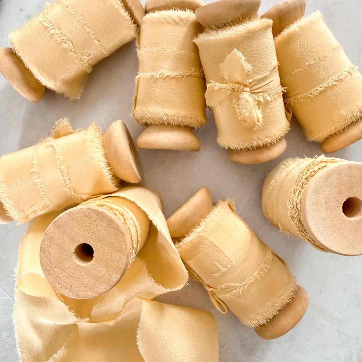 Buttermilk silk ribbon with softly frayed edges for wedding stationery