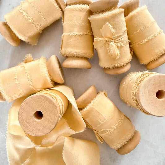 Buttermilk silk ribbon with softly frayed edges for wedding stationery