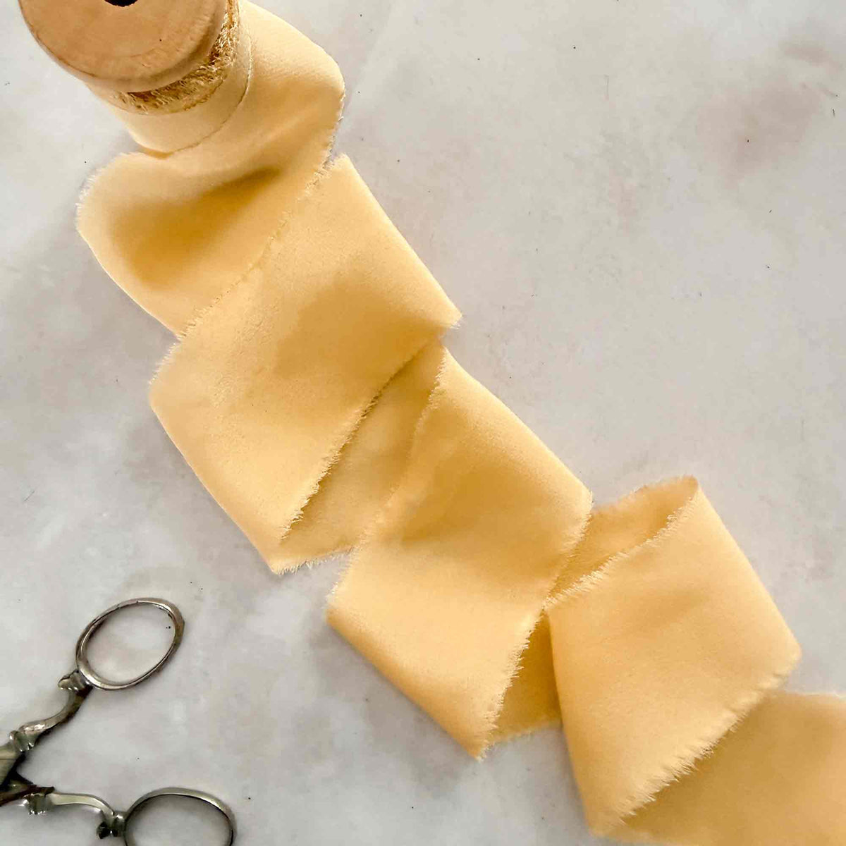 Buttermilk silk ribbon on wooden spool for wedding invitations