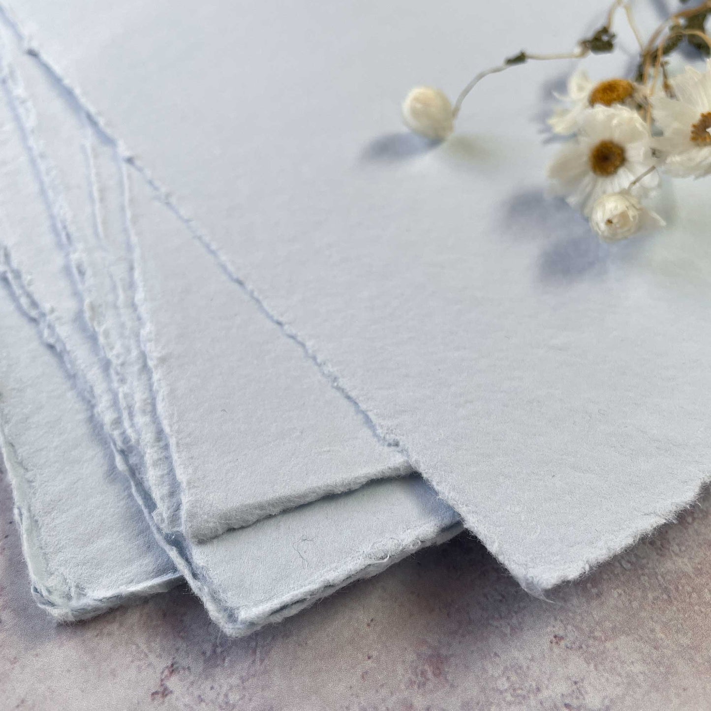 A4 sheets of handmade cotton rag paper in light blue.  Recycled paper with a deckled edge.  Vegan and tree free paper by The Natural Paper Company