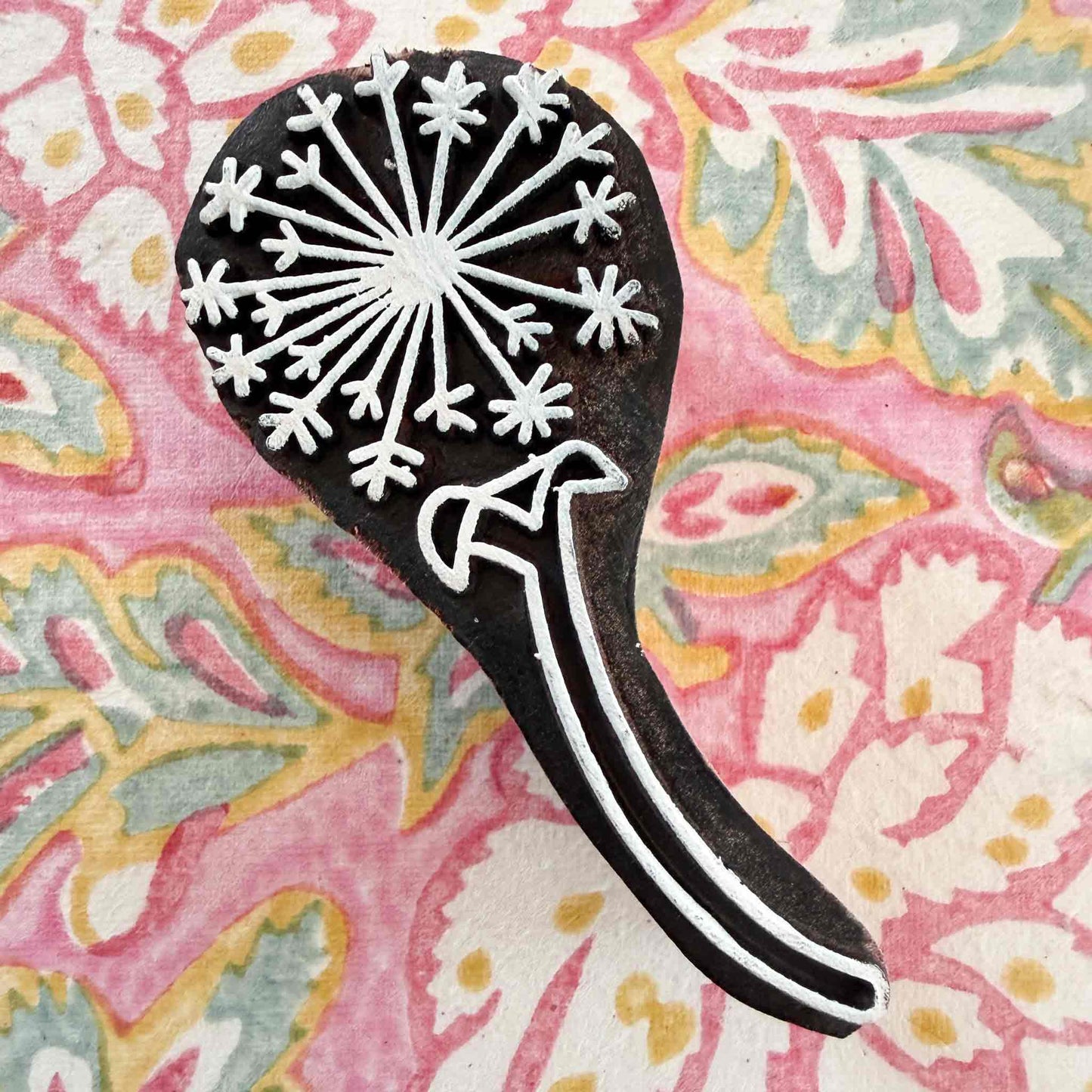 dandelion clock wooden stamp on a decorative wood blocked pattern