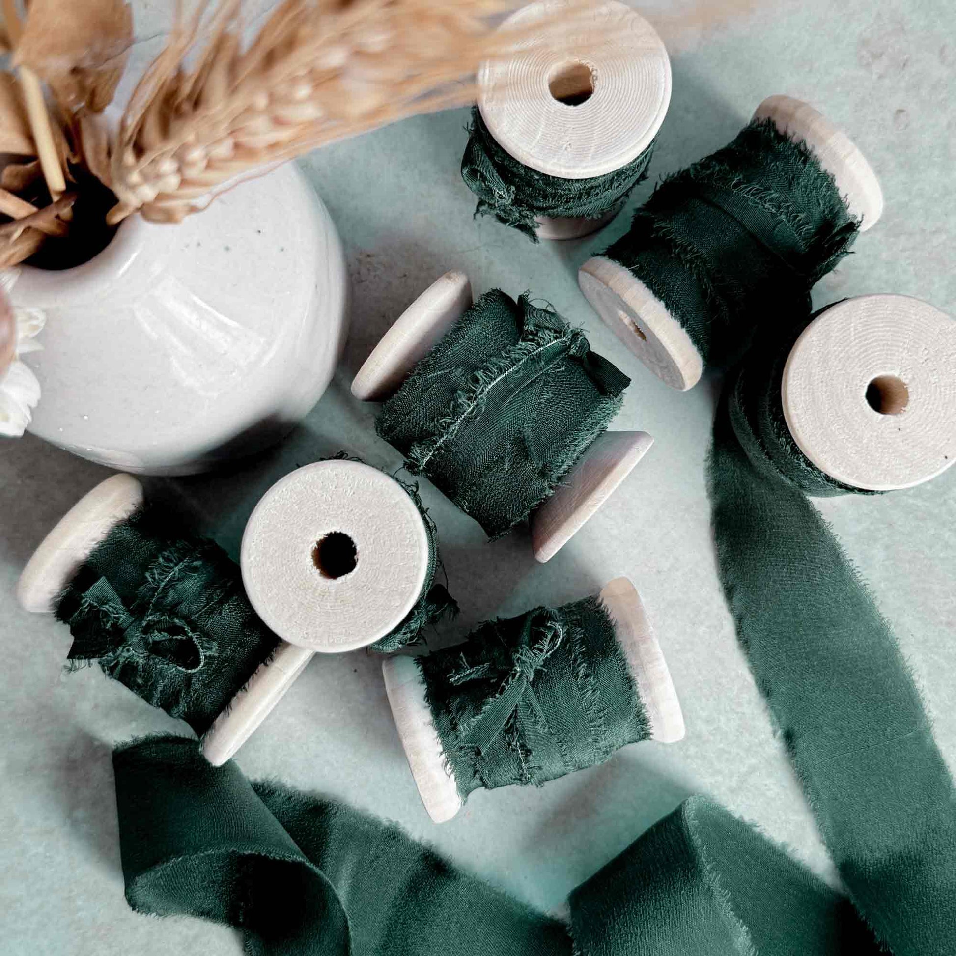 dark green silk ribbon on a wooden reel.